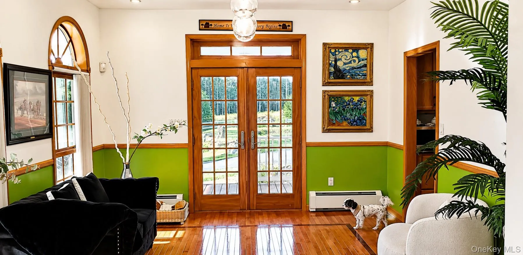 Rich wood-finish flooring extending from French doors, featuring transom windows and sidelights Rich wood-finish flooring extending from French doors, featuring transom windows and sidelights