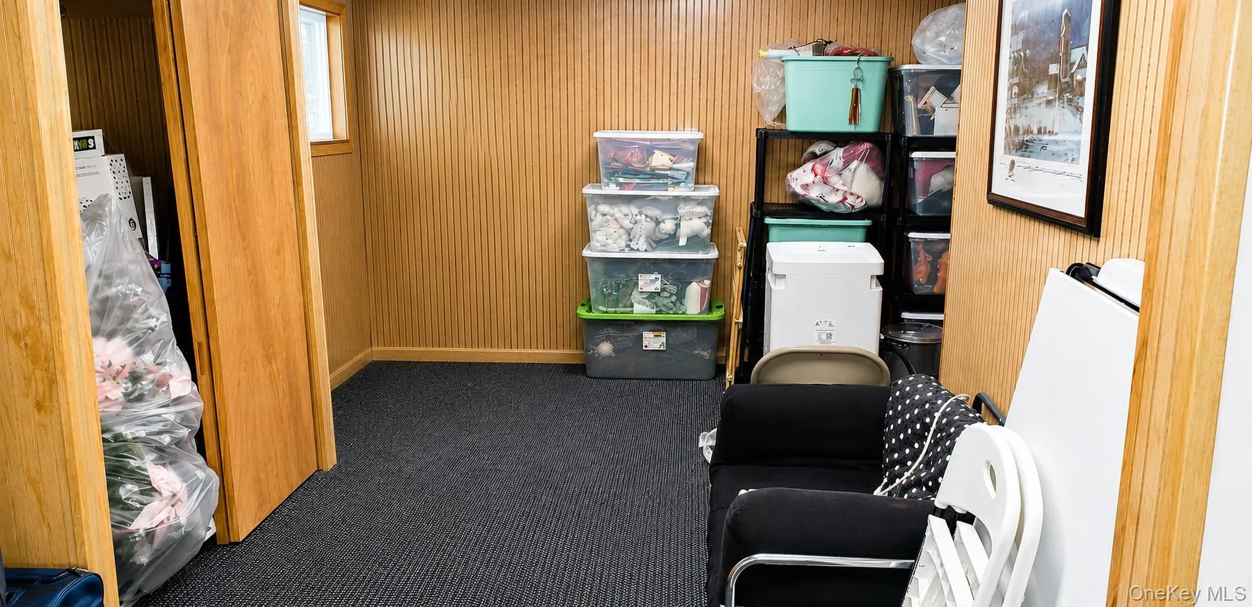 Carpeted interior space featuring wood-finish wall paneling, a recessed window, and a wood-finish door Carpeted interior space featuring wood-finish wall paneling, a recessed window, and a wood-finish door