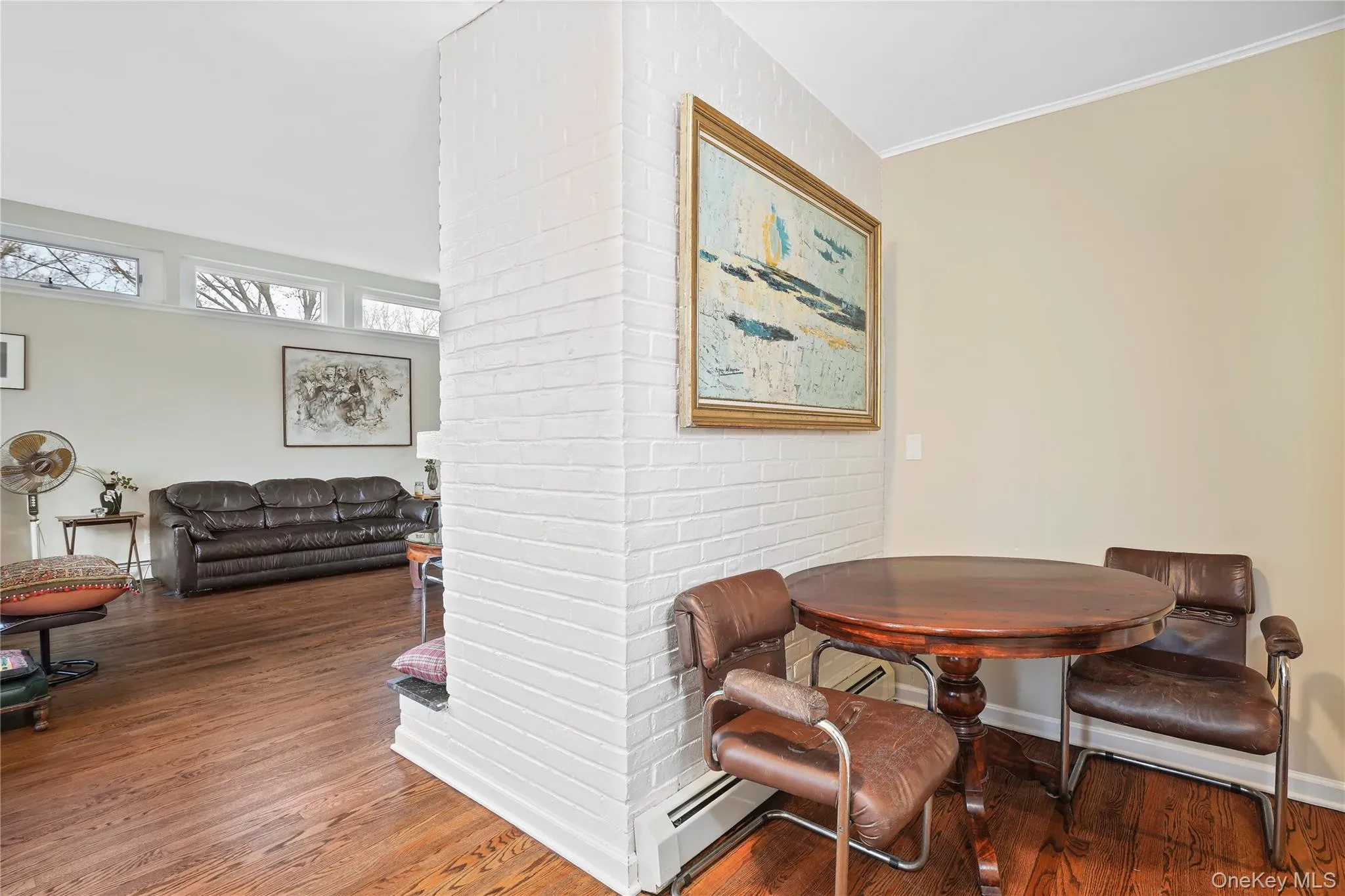Foyer With A Vintage Vibe: Round Wooden Table, Leather Chairs, And A Bright, Art-Filled Backdrop! Foyer With A Vintage Vibe: Round Wooden Table, Leather Chairs, And A Bright, Art-Filled Backdrop!