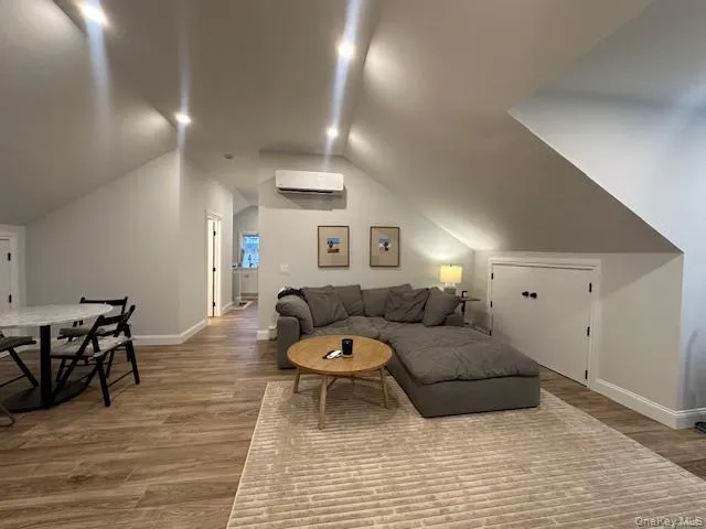Living room featuring lofted ceiling and light wood finished floors Living room featuring lofted ceiling and light wood finished floors