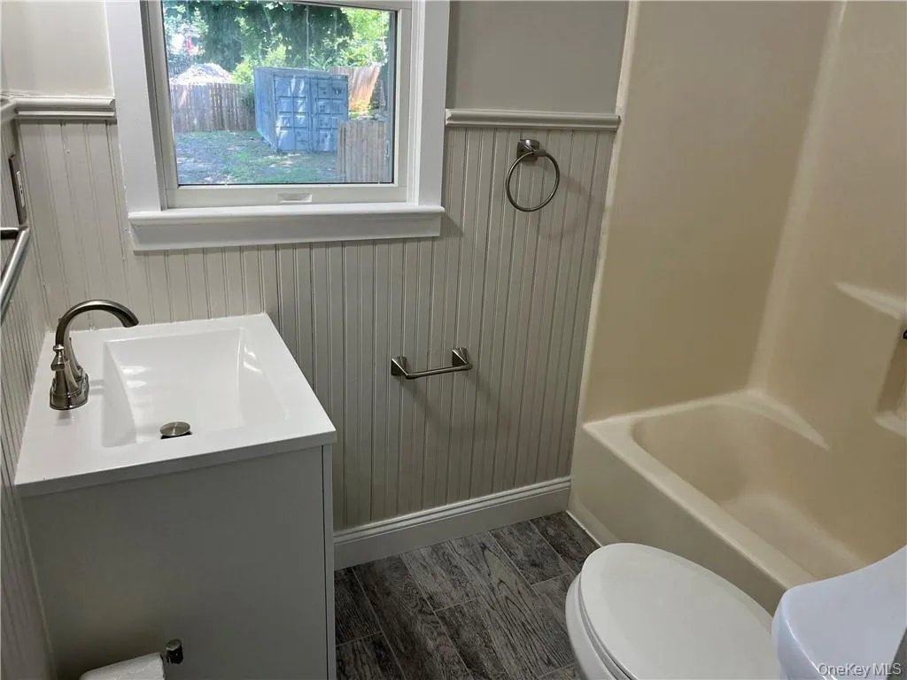 Bathroom featuring wood-type flooring, toilet, and vanity Bathroom featuring wood-type flooring, toilet, and vanity