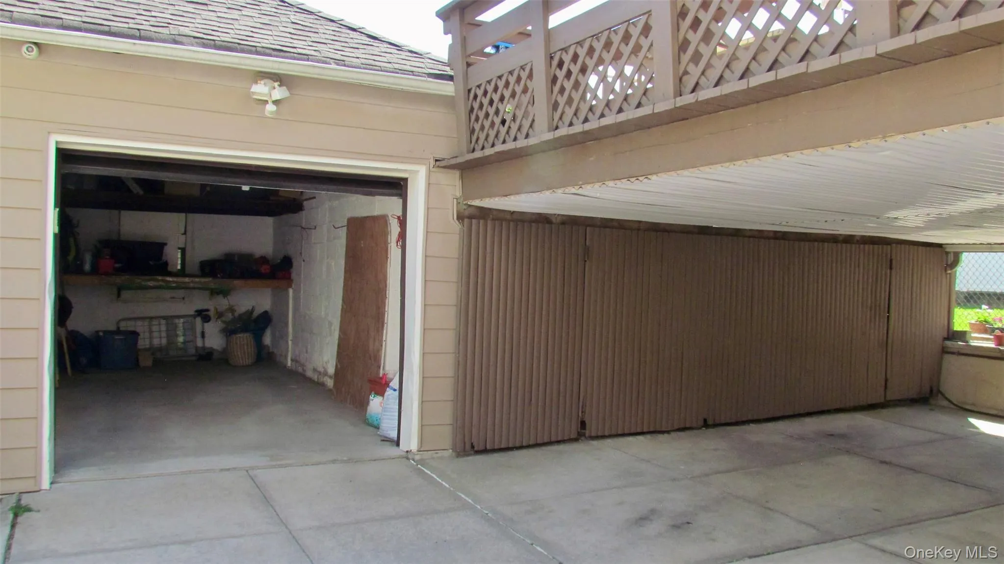One-car garage and additional covered parking pad with a lattice-style railing overhead One-car garage and additional covered parking pad with a lattice-style railing overhead