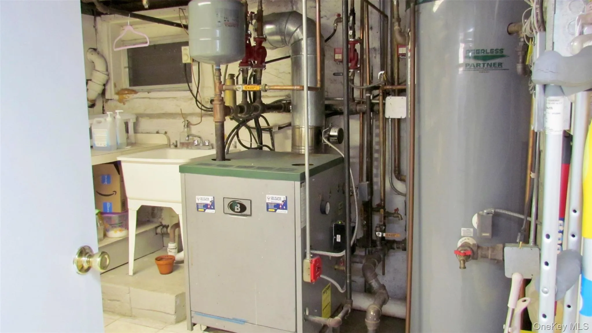 Utility area featuring a boiler, water heater, and a utility sink Utility area featuring a boiler, water heater, and a utility sink