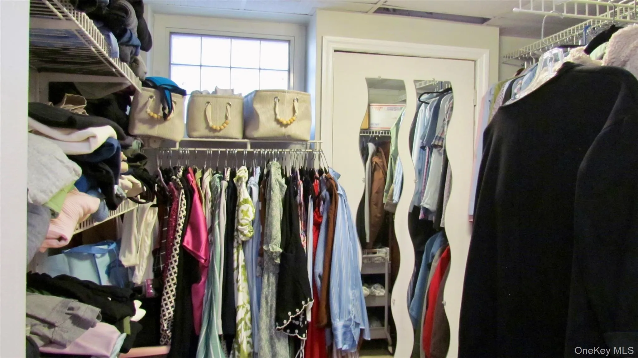 Custom walk-in closet system featuring wire shelving and hanging rods Custom walk-in closet system featuring wire shelving and hanging rods
