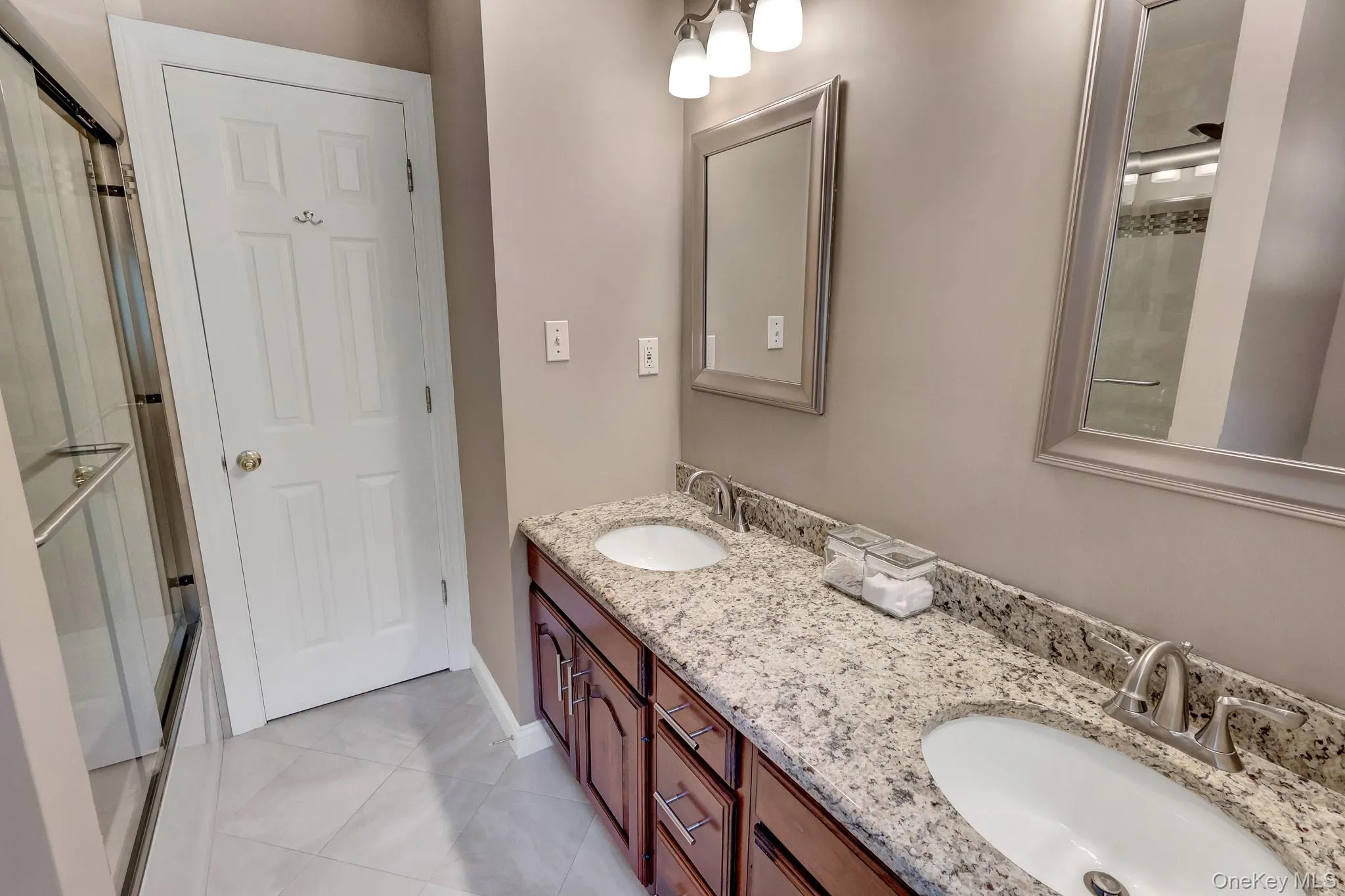 Double vanity with granite-style countertop, dual undermount sinks, and brushed nickel fixtures Double vanity with granite-style countertop, dual undermount sinks, and brushed nickel fixtures