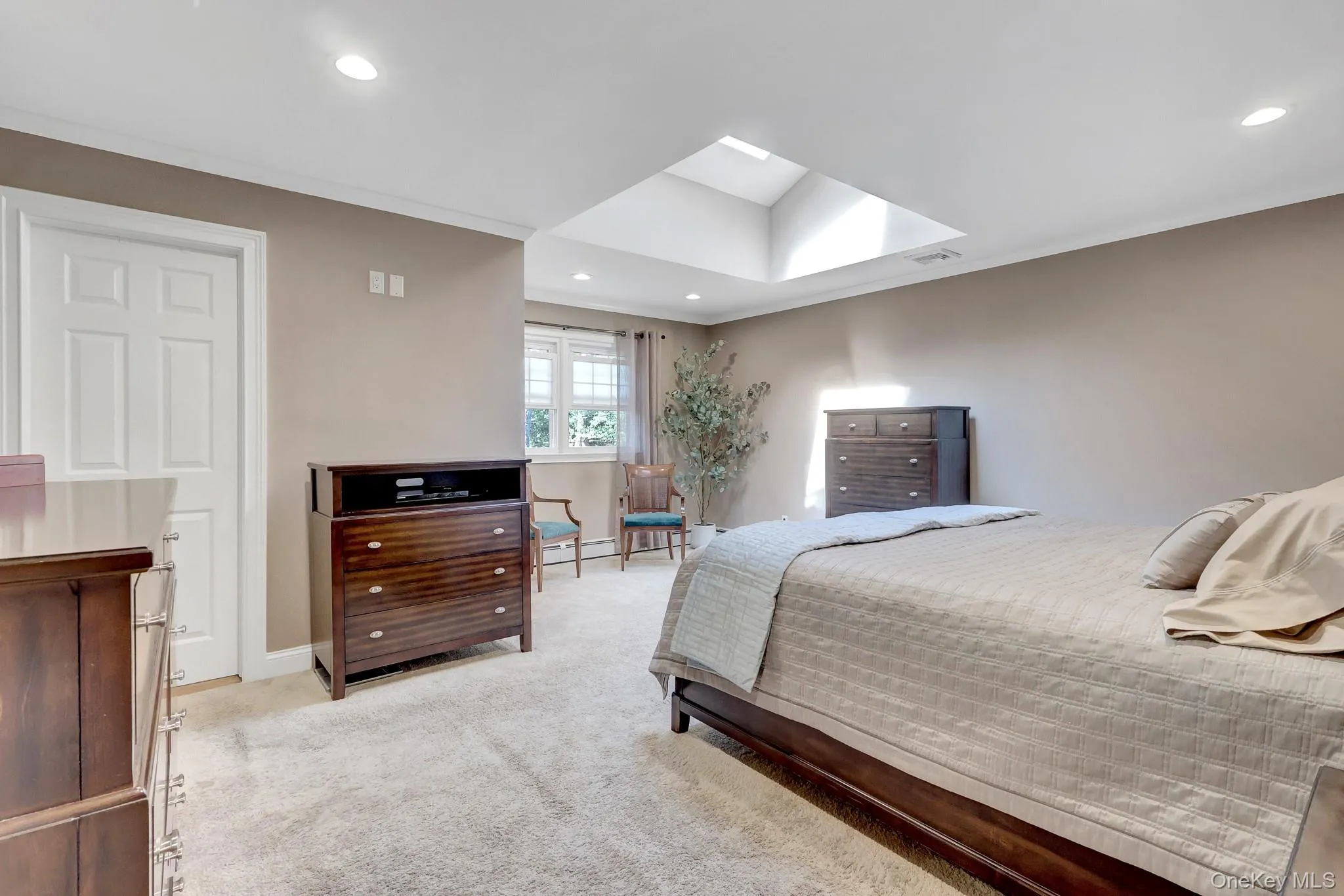 Recessed lighting illuminates this room featuring a skylight and a window with white blinds Recessed lighting illuminates this room featuring a skylight and a window with white blinds