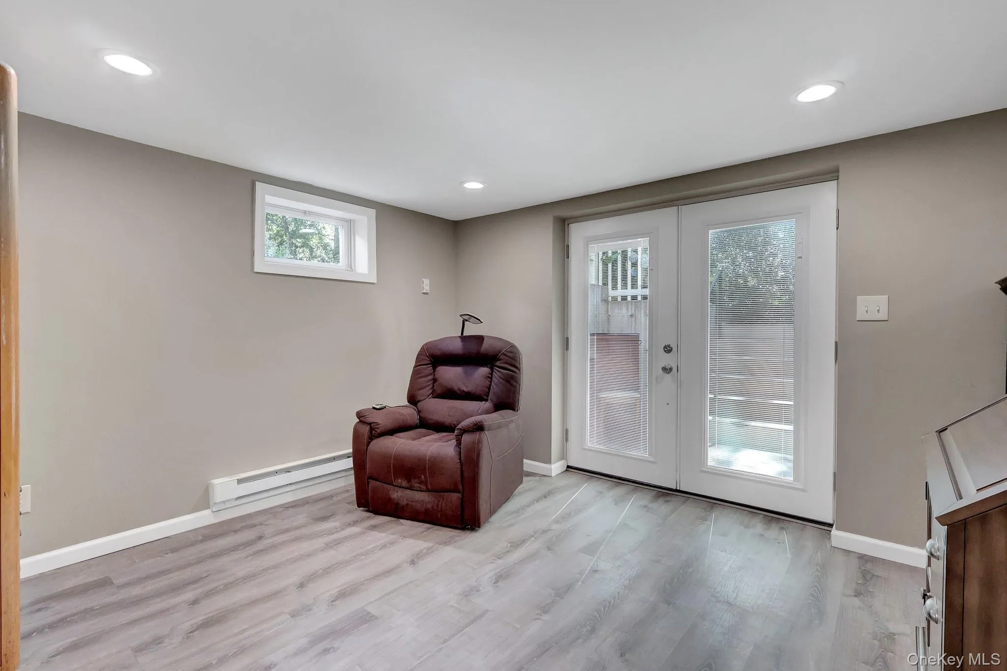 Room featuring wood-finish flooring, recessed lighting, and a neutral wall color Room featuring wood-finish flooring, recessed lighting, and a neutral wall color