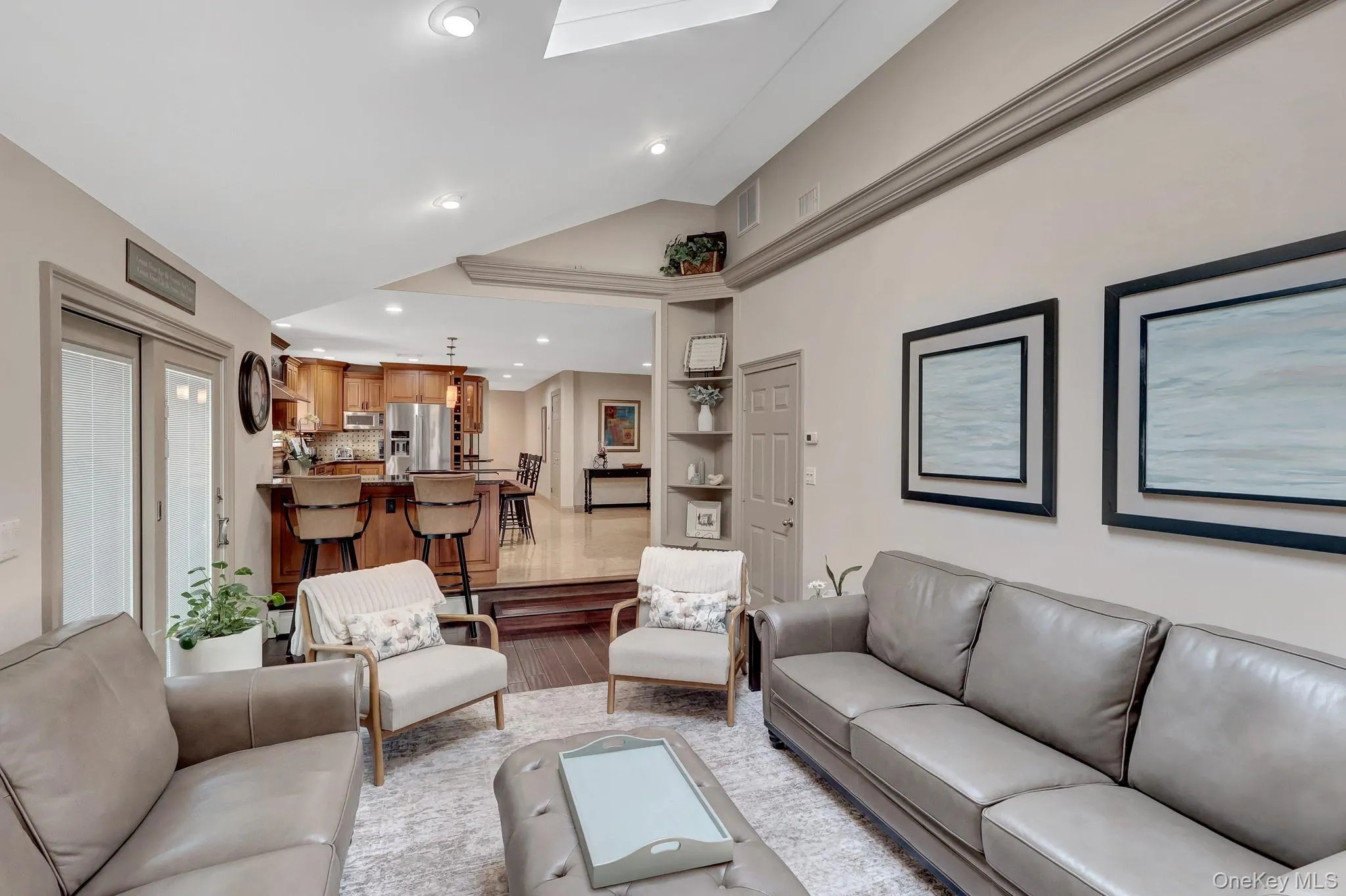 Spacious living area featuring recessed lighting, a vaulted ceiling, and sliding glass doors Spacious living area featuring recessed lighting, a vaulted ceiling, and sliding glass doors