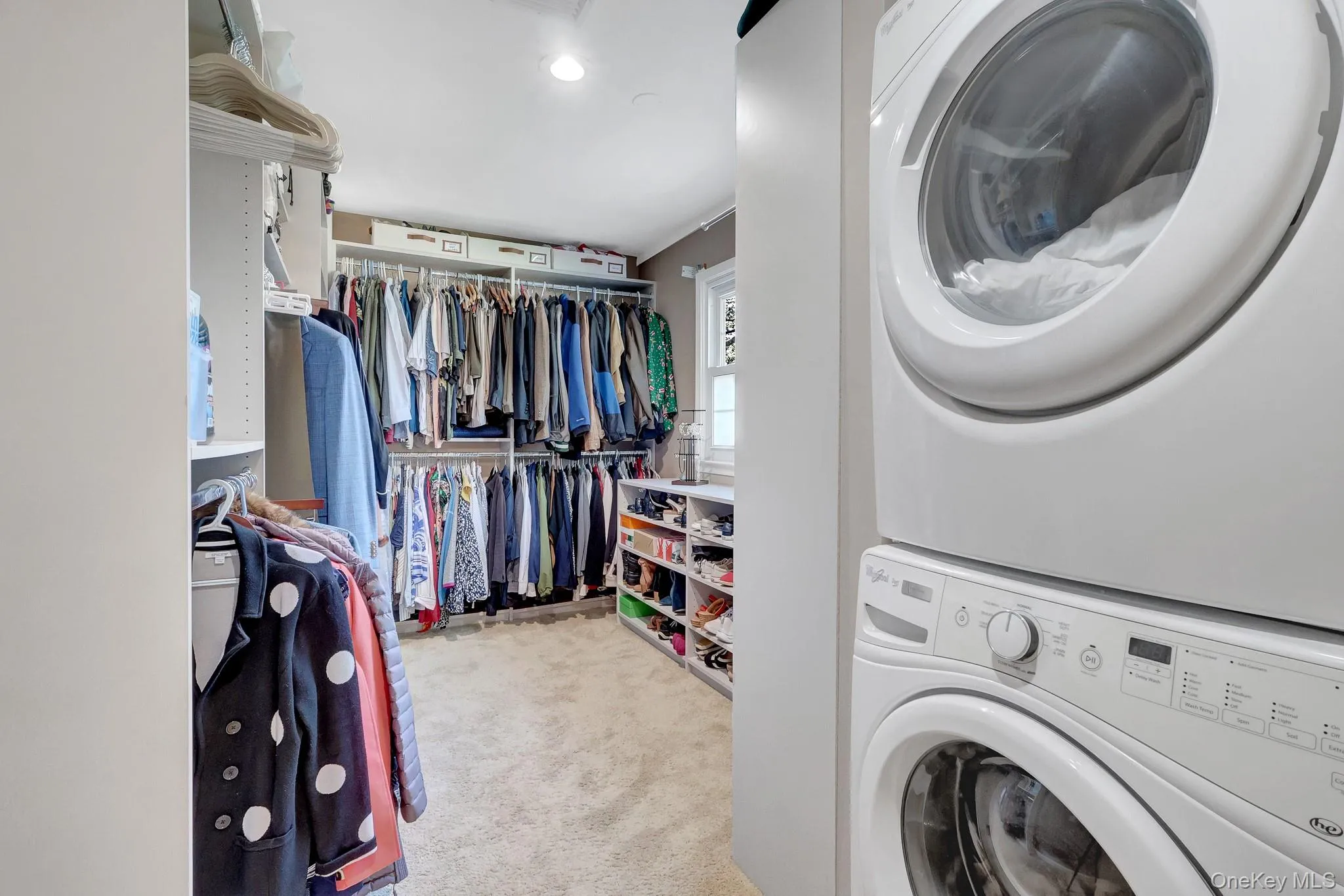 Walk-in closet with carpet flooring and ample storage and second-floor laundry. Walk-in closet with carpet flooring and ample storage and second-floor laundry.