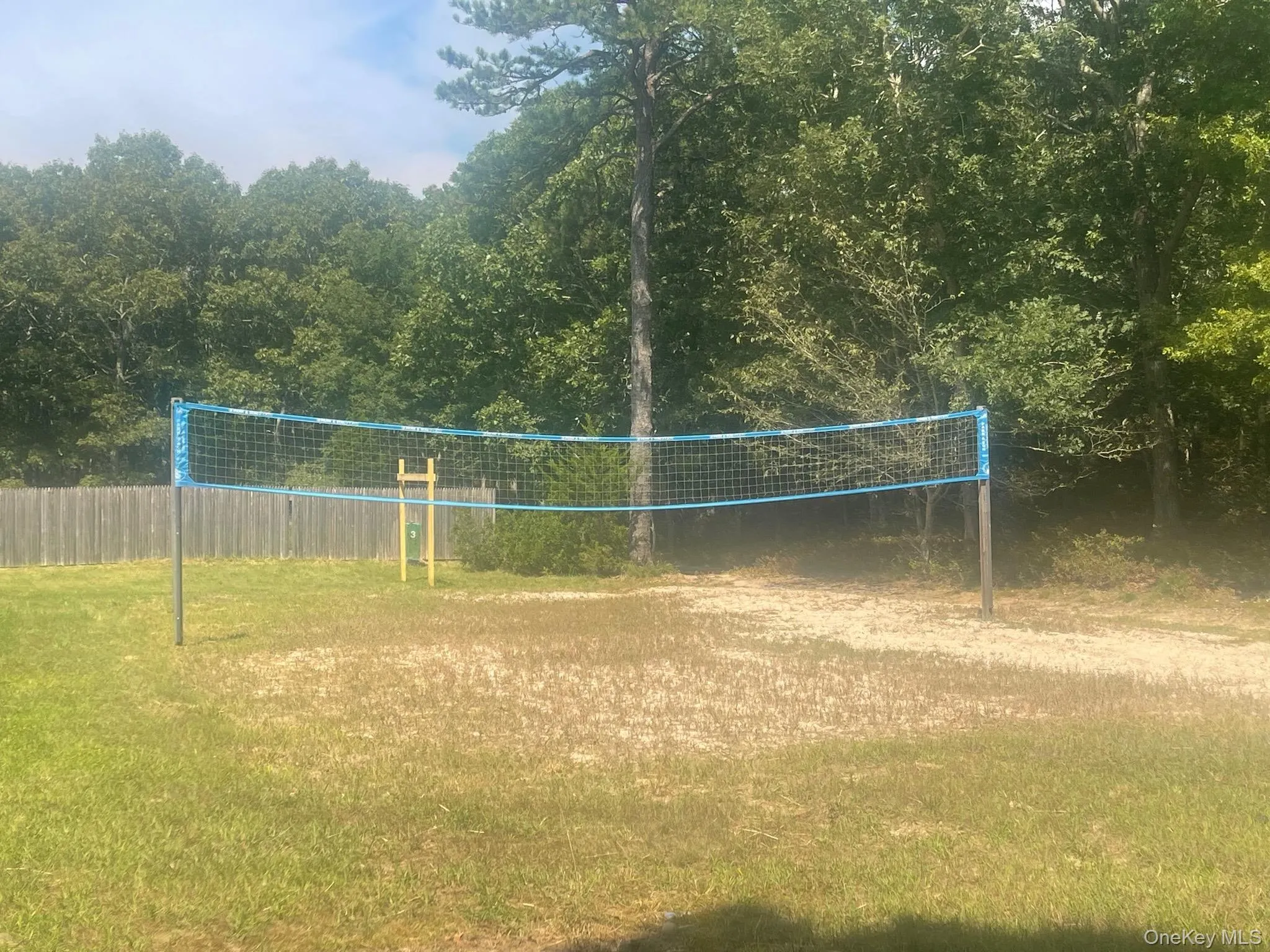 Grassed area featuring a volleyball net Grassed area featuring a volleyball net