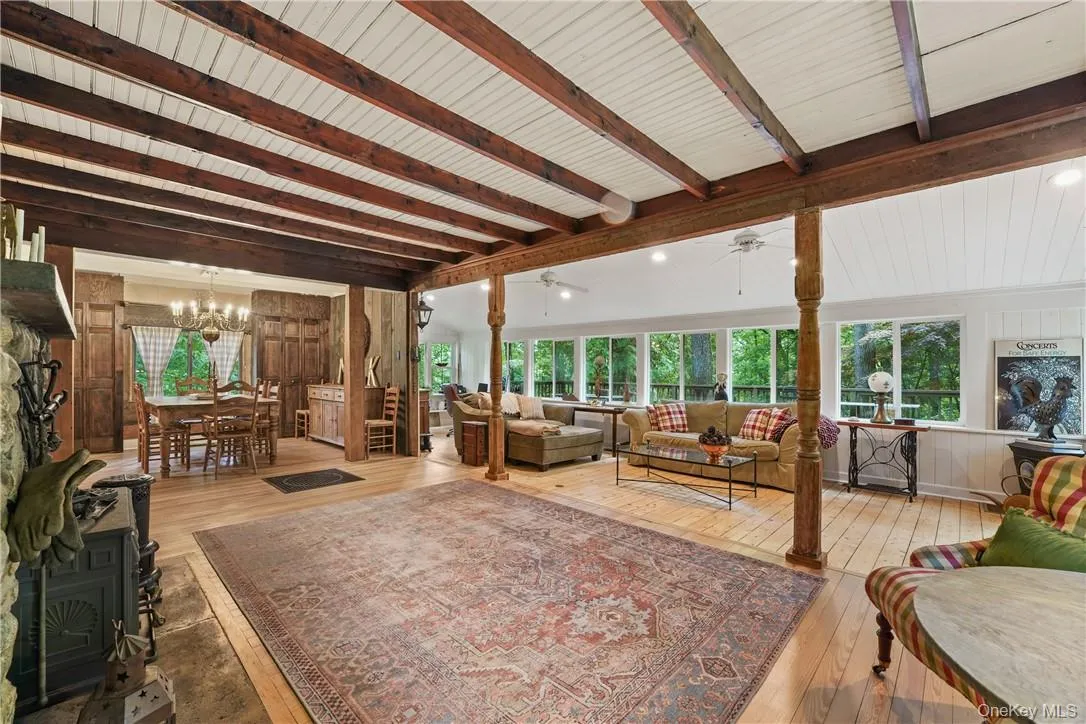 Sunny living room with hardwood floors, wood stove, and ceiling fans Sunny living room with hardwood floors, wood stove, and ceiling fans