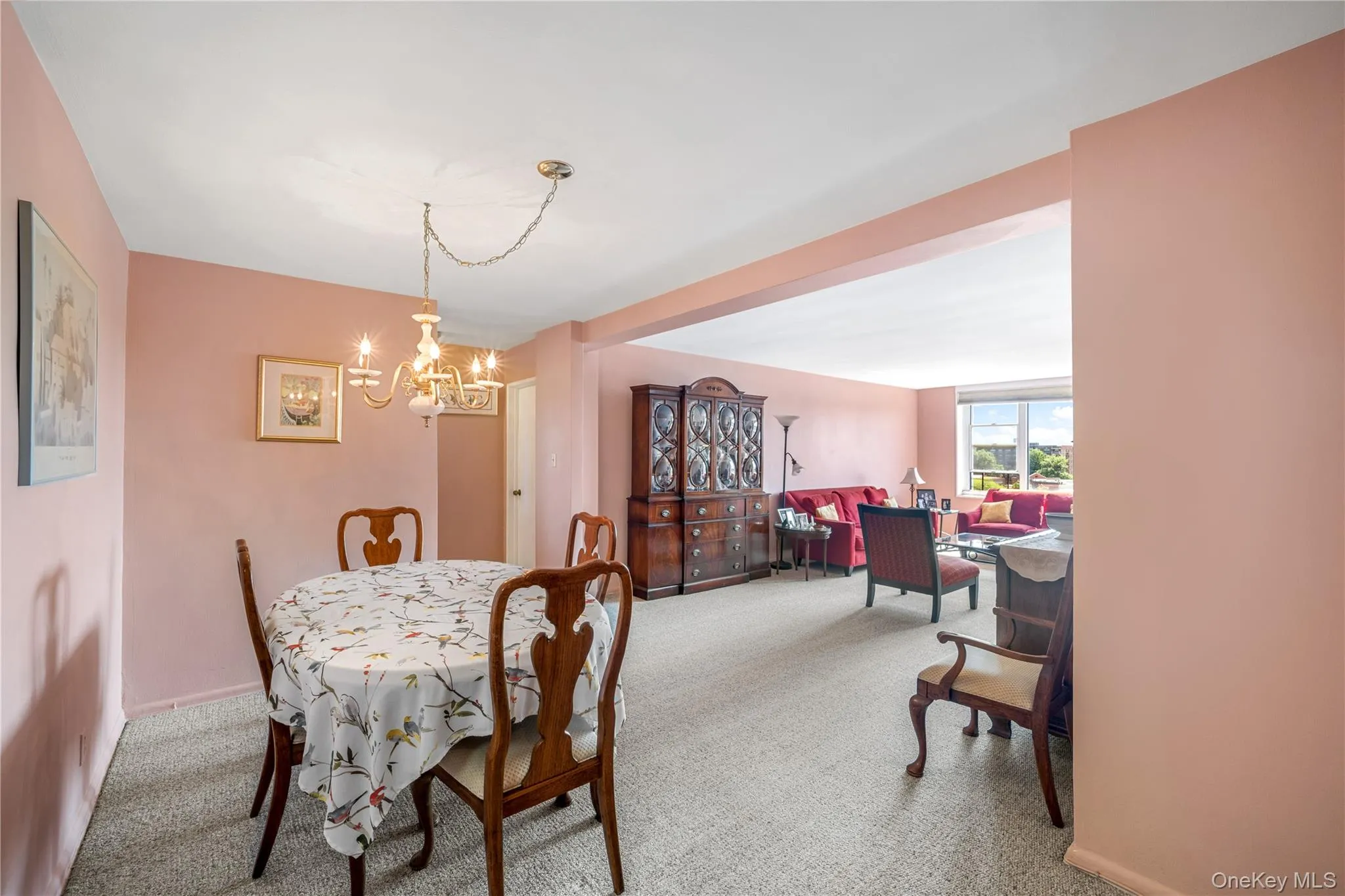 Carpeted dining area with a chandelier, offering a wide entry to the living space Carpeted dining area with a chandelier, offering a wide entry to the living space