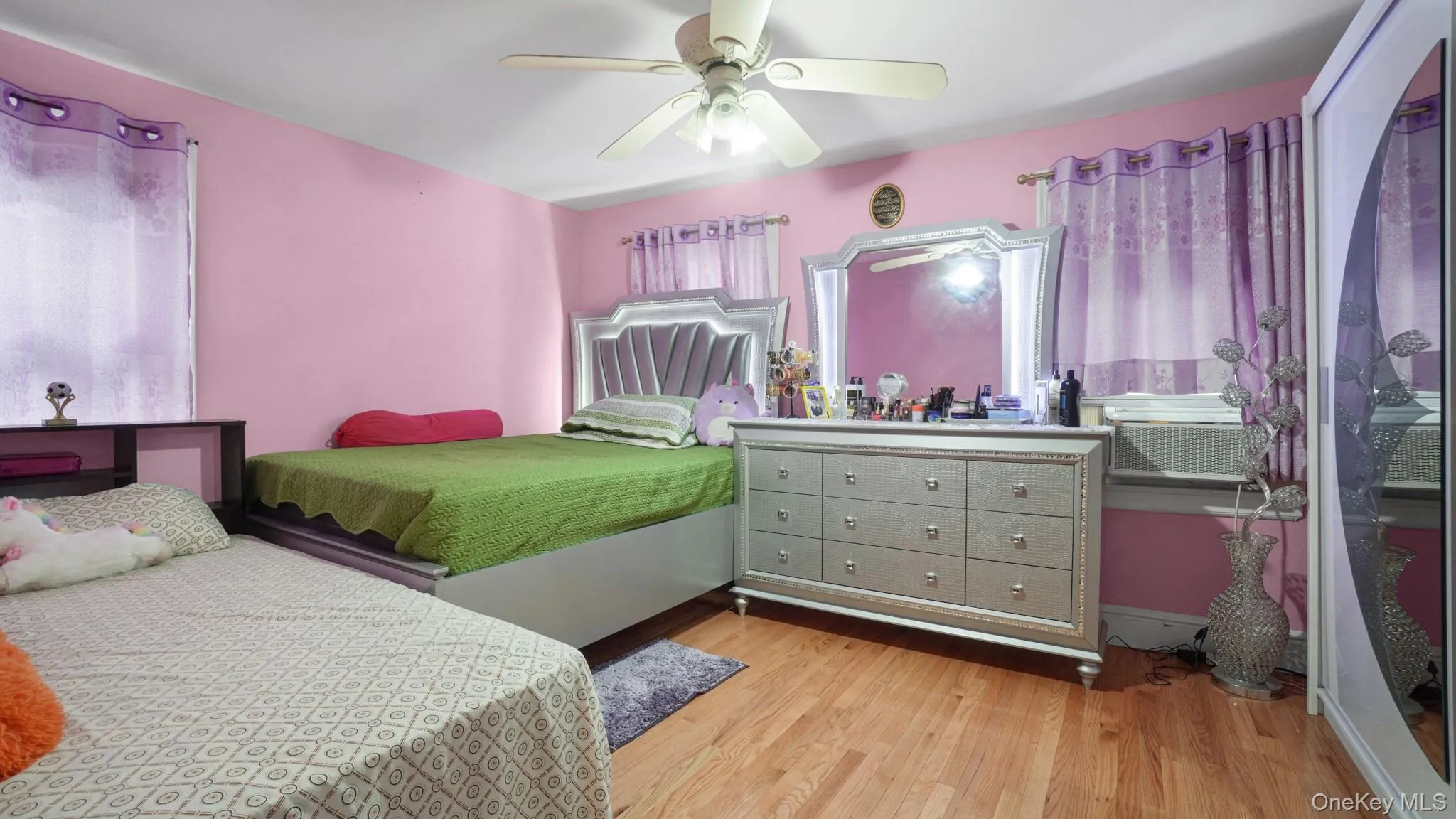 Bedroom featuring wood finished floors, ceiling fan, and cooling unit Bedroom featuring wood finished floors, ceiling fan, and cooling unit