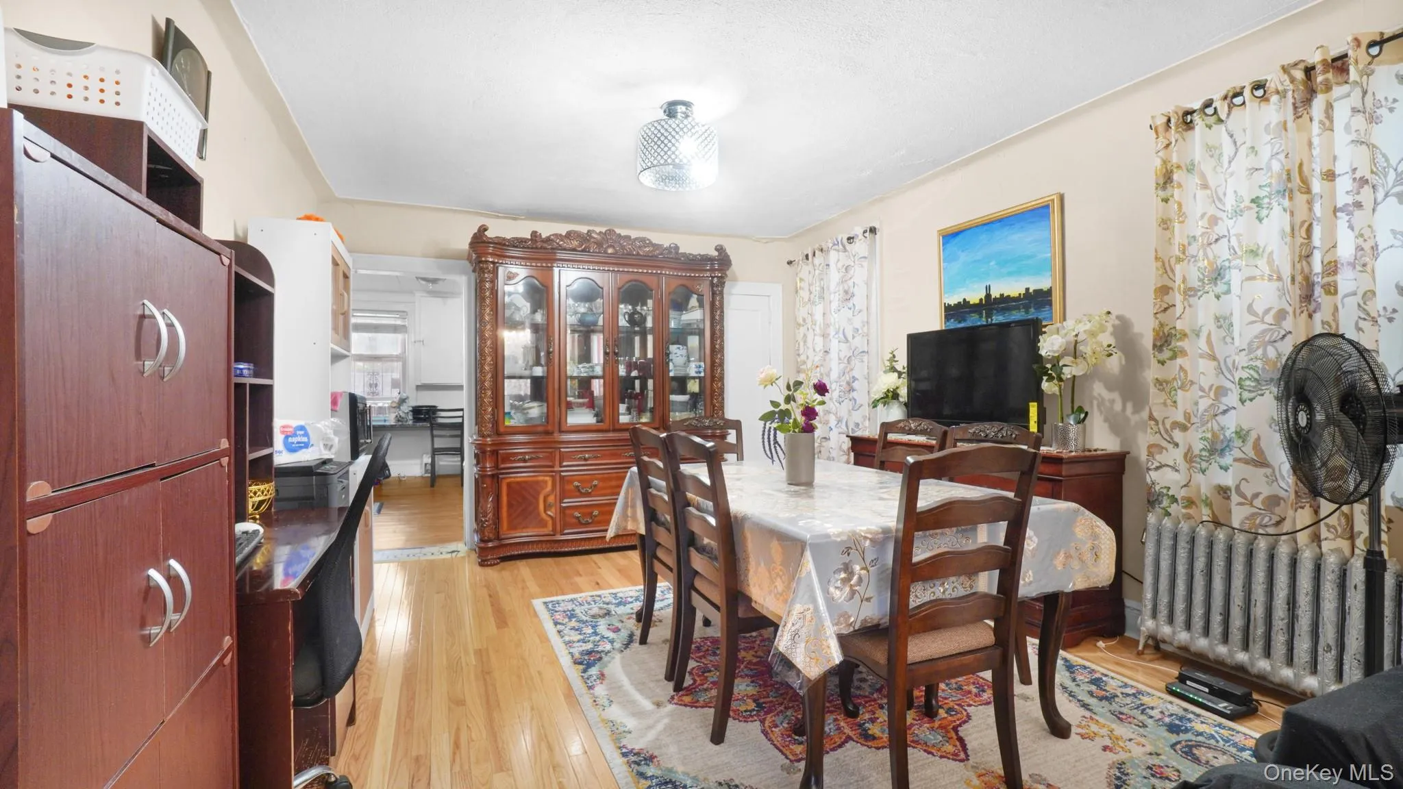 Dining area with radiator and light wood-style floors Dining area with radiator and light wood-style floors