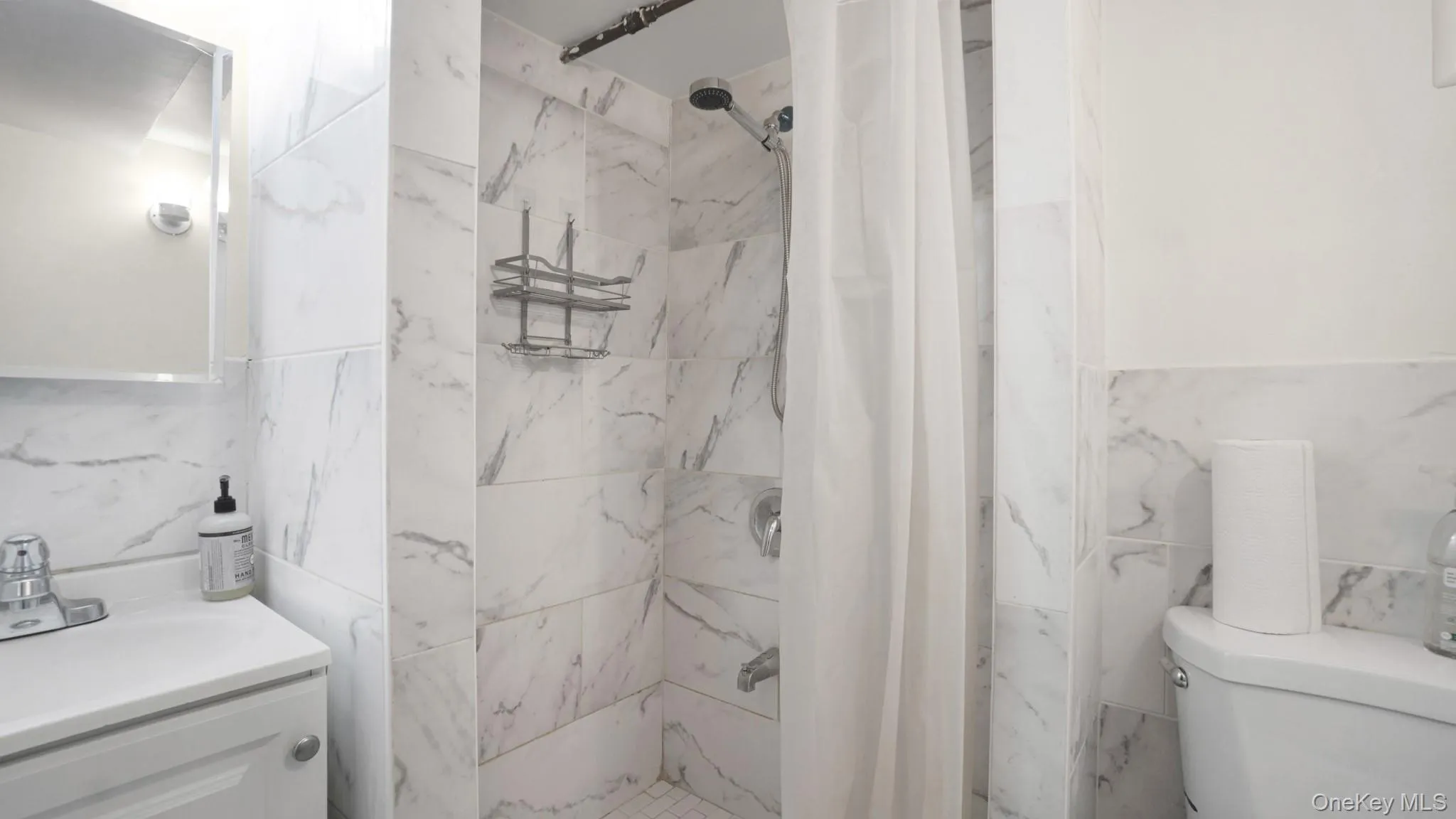 Full bath featuring tile walls, vanity, and a shower stall Full bath featuring tile walls, vanity, and a shower stall