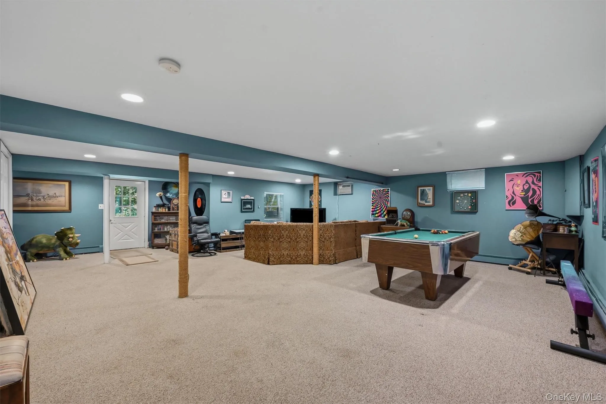 Spacious recreational area featuring carpet flooring, recessed lighting, and teal painted walls Spacious recreational area featuring carpet flooring, recessed lighting, and teal painted walls