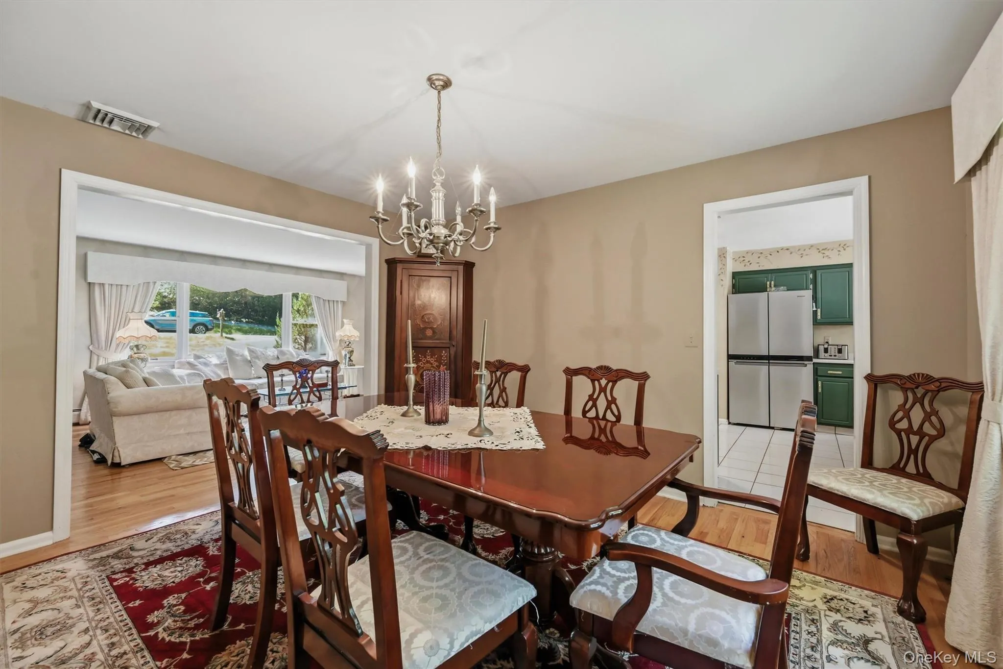 Formal dining area featuring hardwood flooring, a candelabra-style chandelier, and a built-in corner hutch Formal dining area featuring hardwood flooring, a candelabra-style chandelier, and a built-in corner hutch