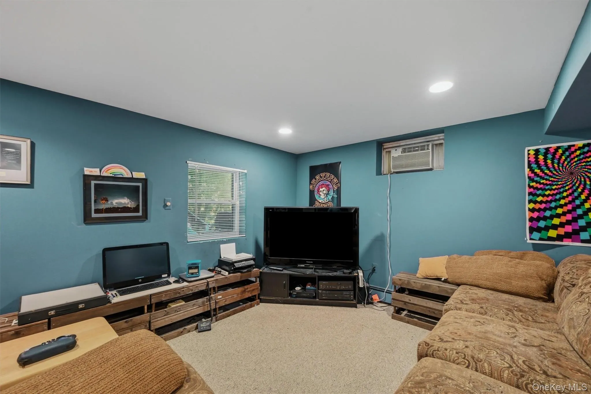 Carpeted room featuring a window with blinds, recessed lighting, and a wall-mounted air conditioning unit Carpeted room featuring a window with blinds, recessed lighting, and a wall-mounted air conditioning unit