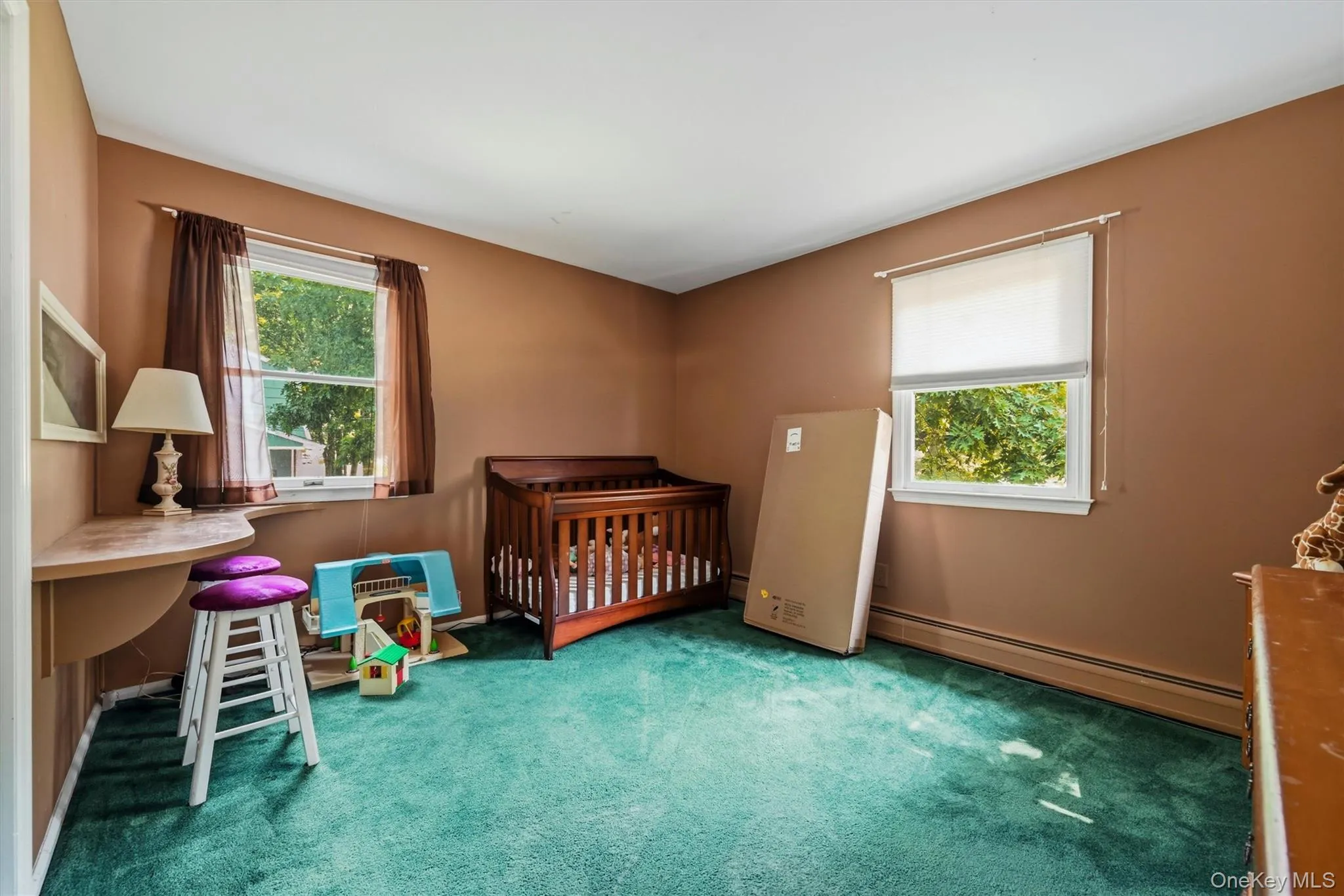 Spacious room featuring two large windows with white trim, offering ample natural light Spacious room featuring two large windows with white trim, offering ample natural light