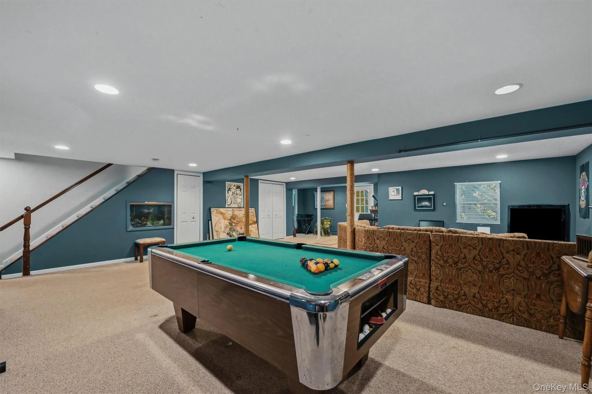 Finished lower level featuring recessed lighting, carpeting, and a wood-finish staircase with white risers Finished lower level featuring recessed lighting, carpeting, and a wood-finish staircase with white risers
