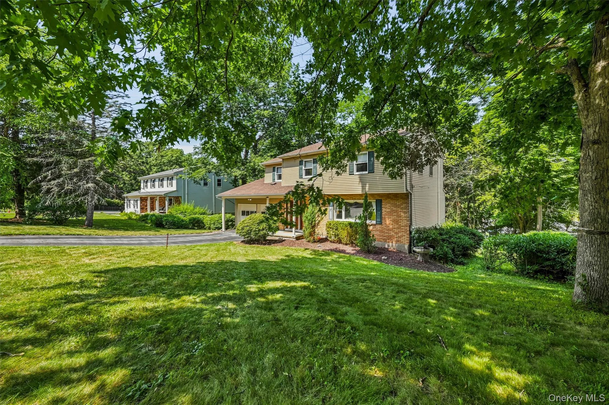 Exterior featuring a two-story design with a hip roof, attached garage, and a covered front porch Exterior featuring a two-story design with a hip roof, attached garage, and a covered front porch