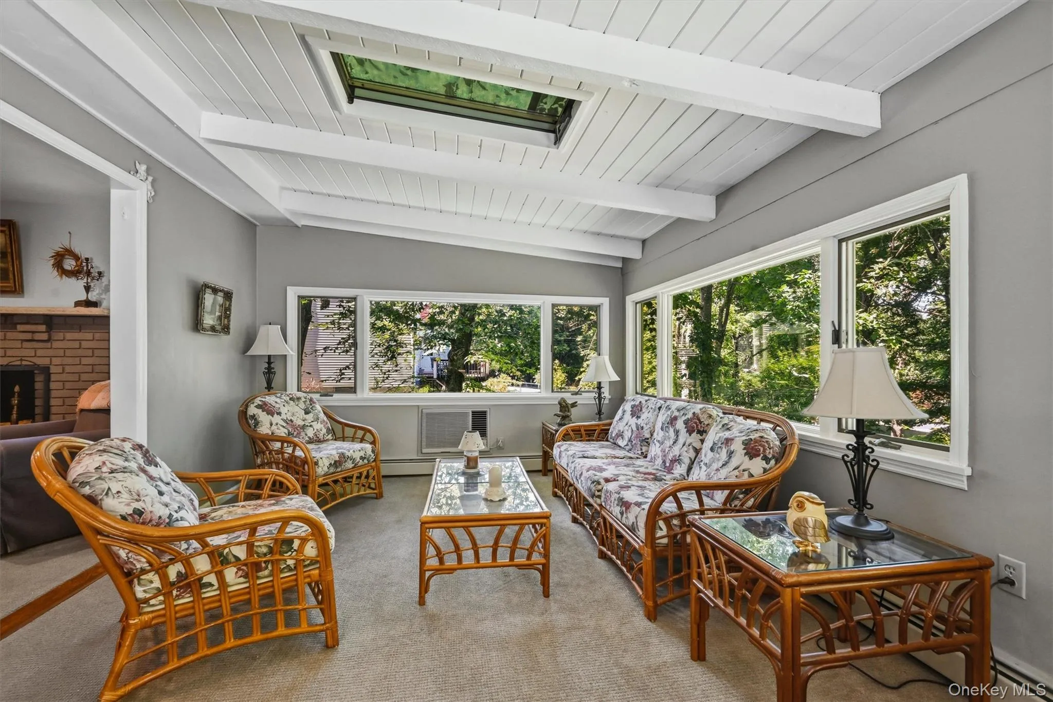 Sunroom with abundant natural light, a skylight, and expansive windows offering peaceful outdoor views. Sunroom with abundant natural light, a skylight, and expansive windows offering peaceful outdoor views.
