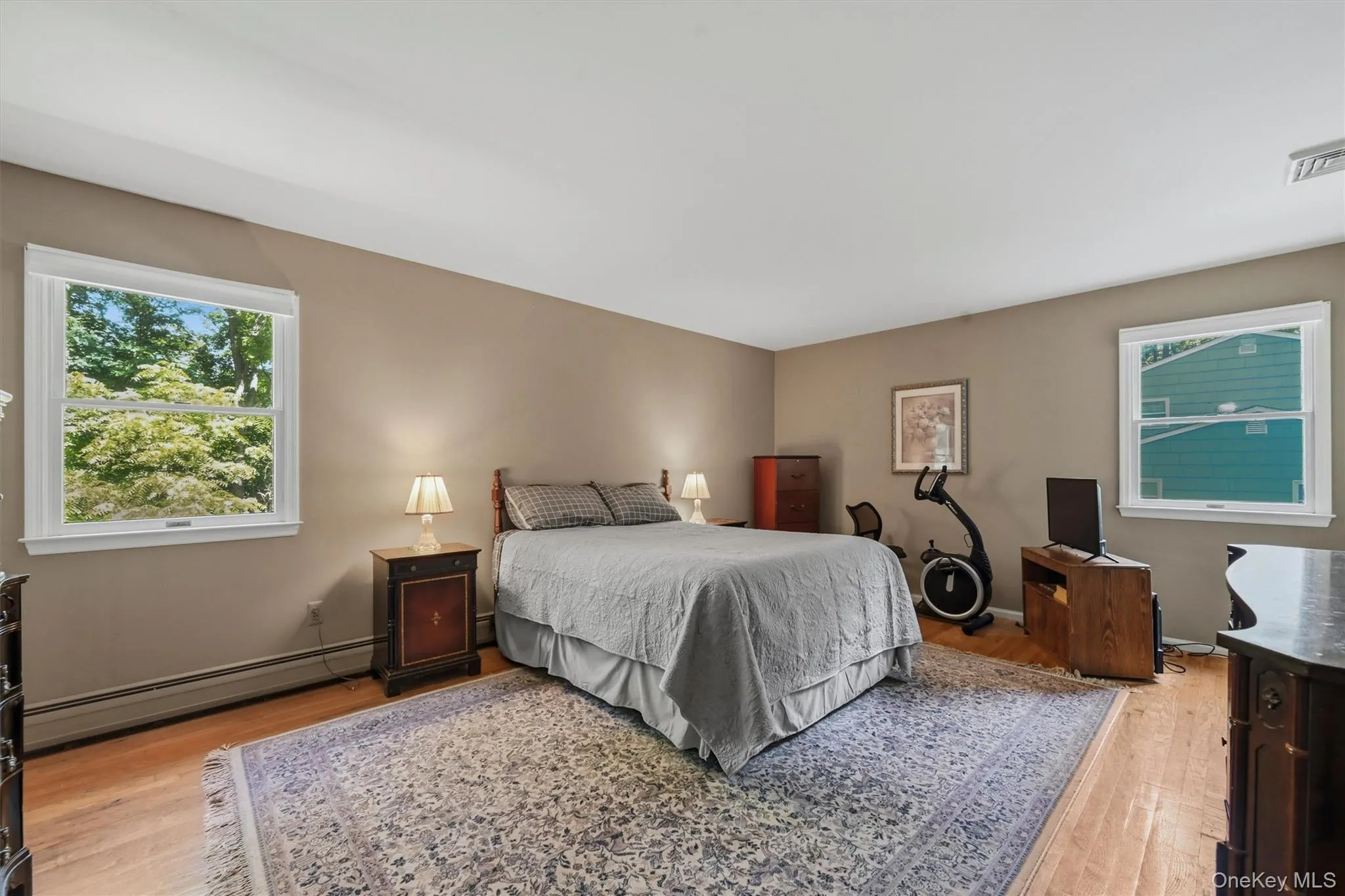 Spacious interior featuring wood-finish flooring, neutral wall tones, and white trim Spacious interior featuring wood-finish flooring, neutral wall tones, and white trim