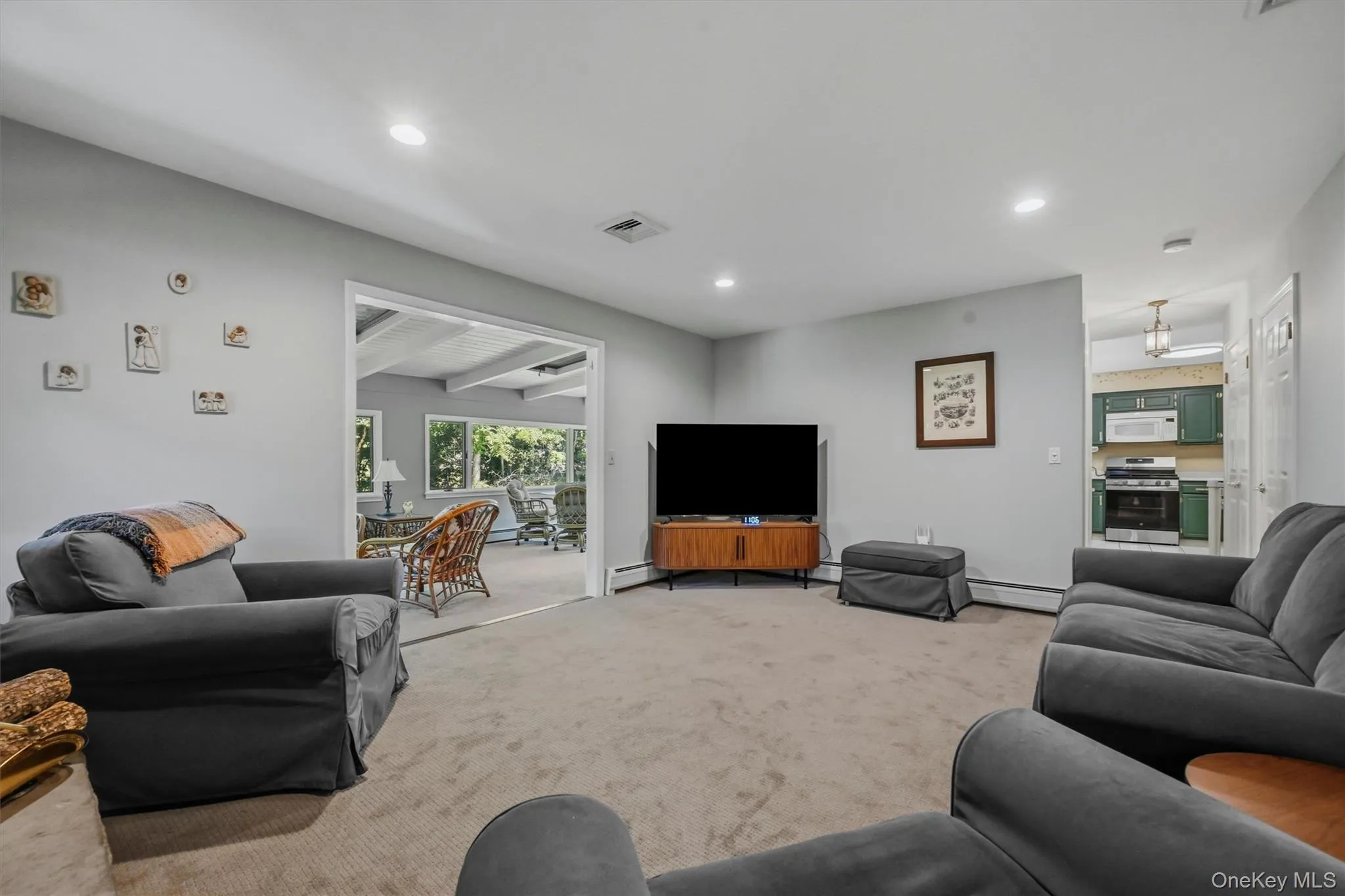 Spacious living area featuring neutral carpeting and recessed lighting Spacious living area featuring neutral carpeting and recessed lighting