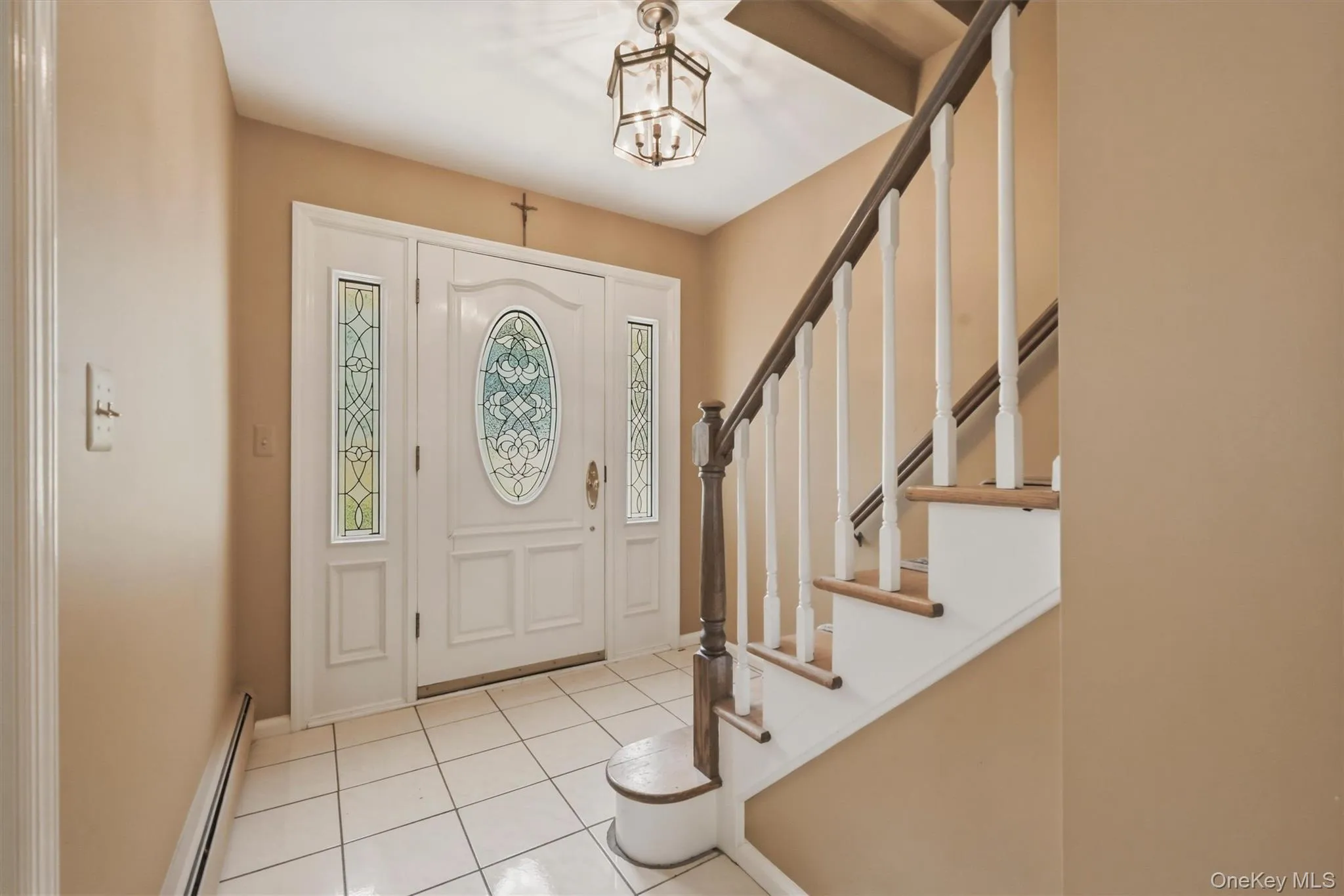 Entryway featuring a white door with decorative glass inserts, flanking sidelights, and a transom window Entryway featuring a white door with decorative glass inserts, flanking sidelights, and a transom window