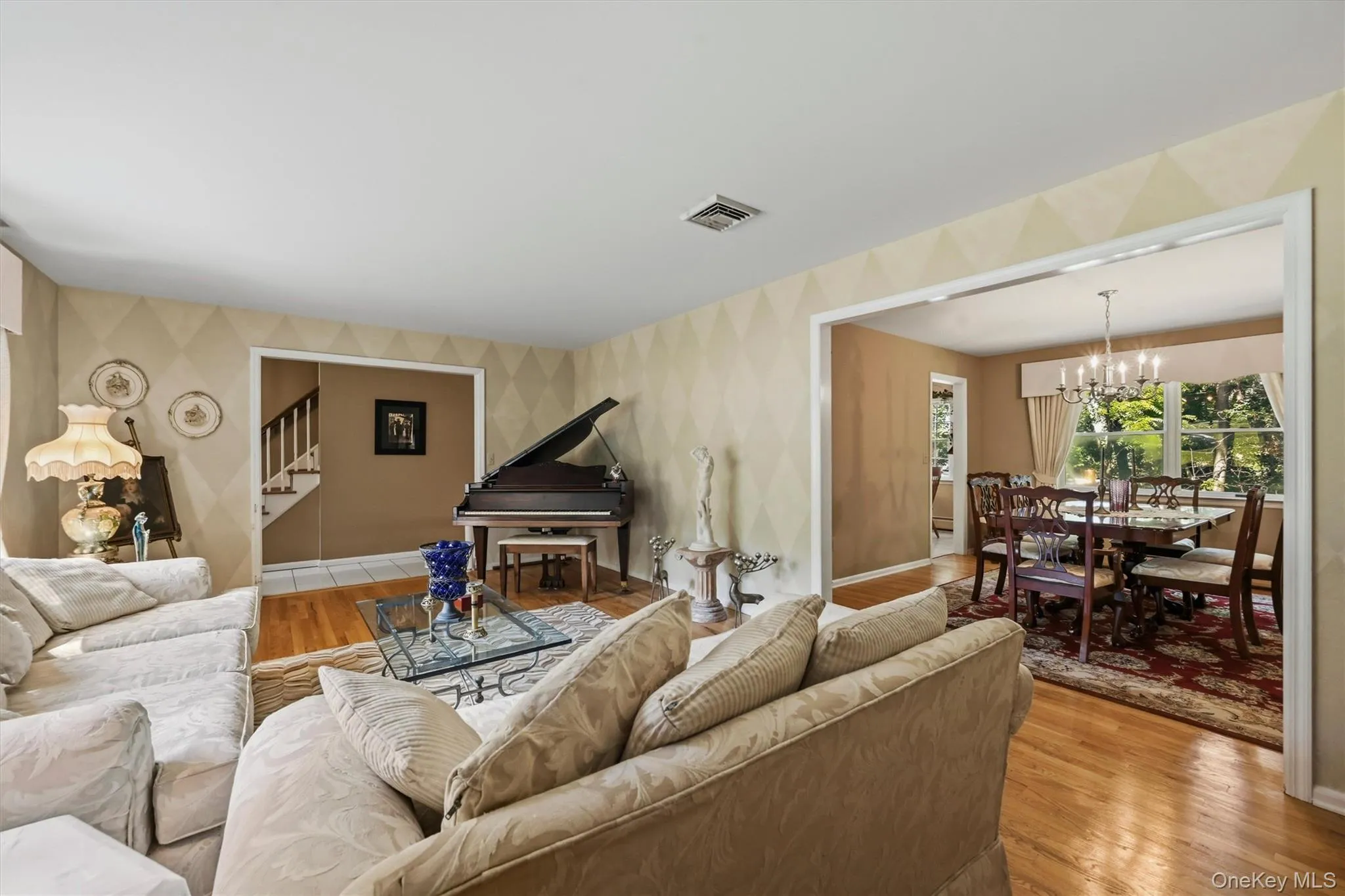 Living area featuring hardwood flooring and patterned wall finishes Living area featuring hardwood flooring and patterned wall finishes