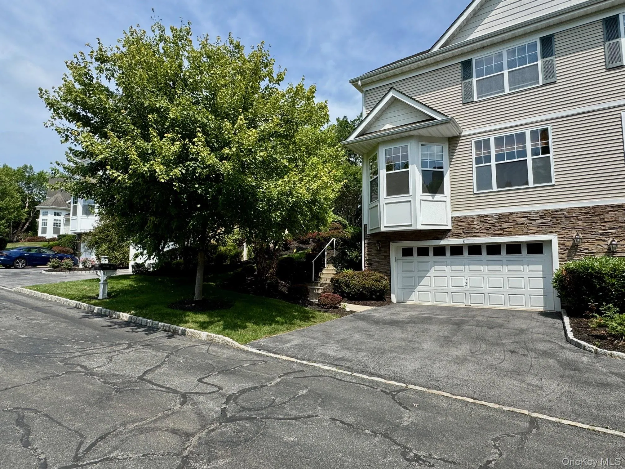 View of front facade with asphalt driveway, a garage, and stone siding View of front facade with asphalt driveway, a garage, and stone siding