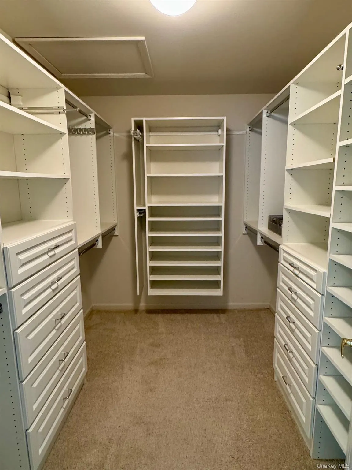 Spacious closet featuring carpet floors and attic access Spacious closet featuring carpet floors and attic access