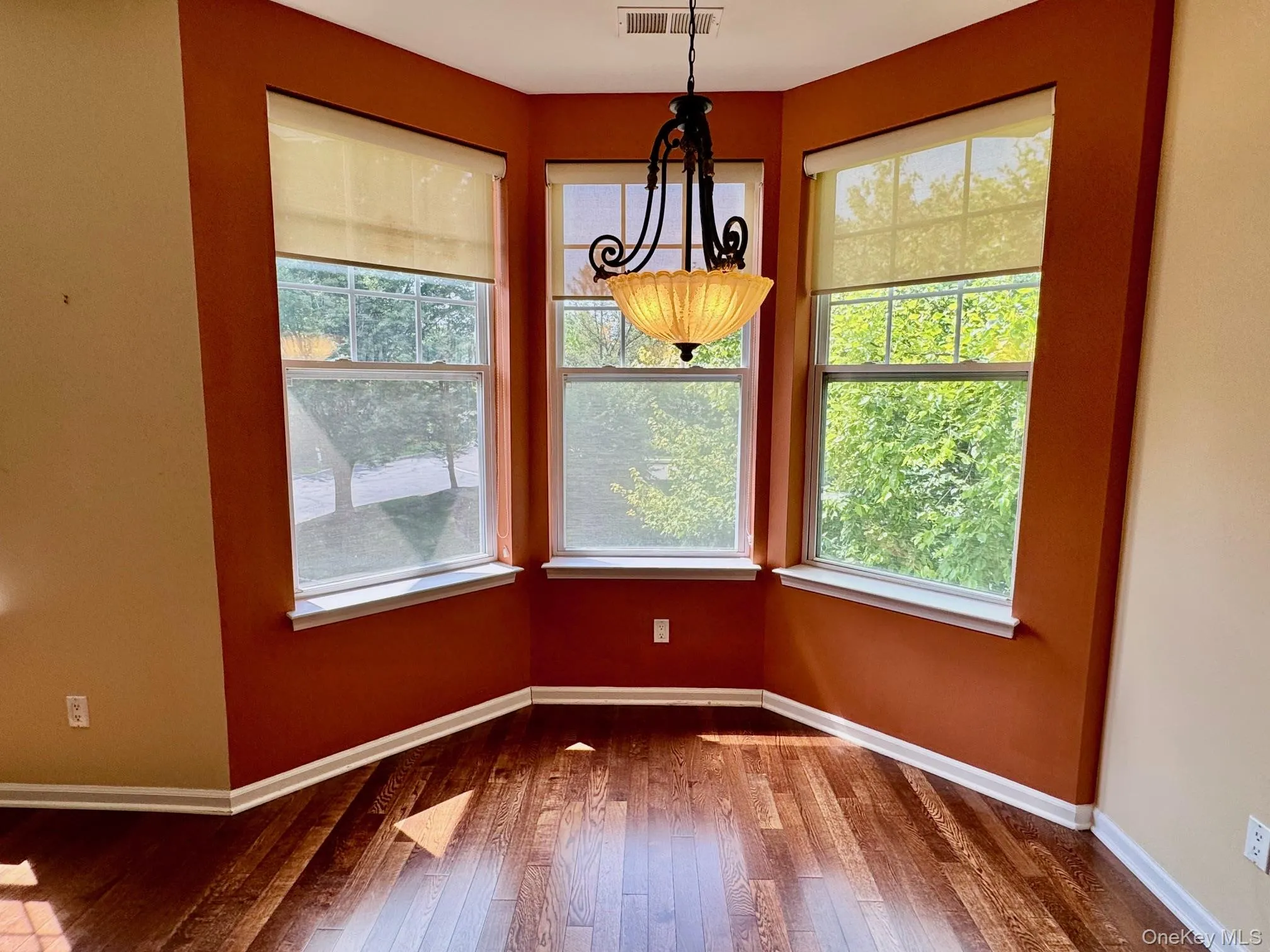 Unfurnished dining area featuring dark wood-style flooring and baseboards Unfurnished dining area featuring dark wood-style flooring and baseboards