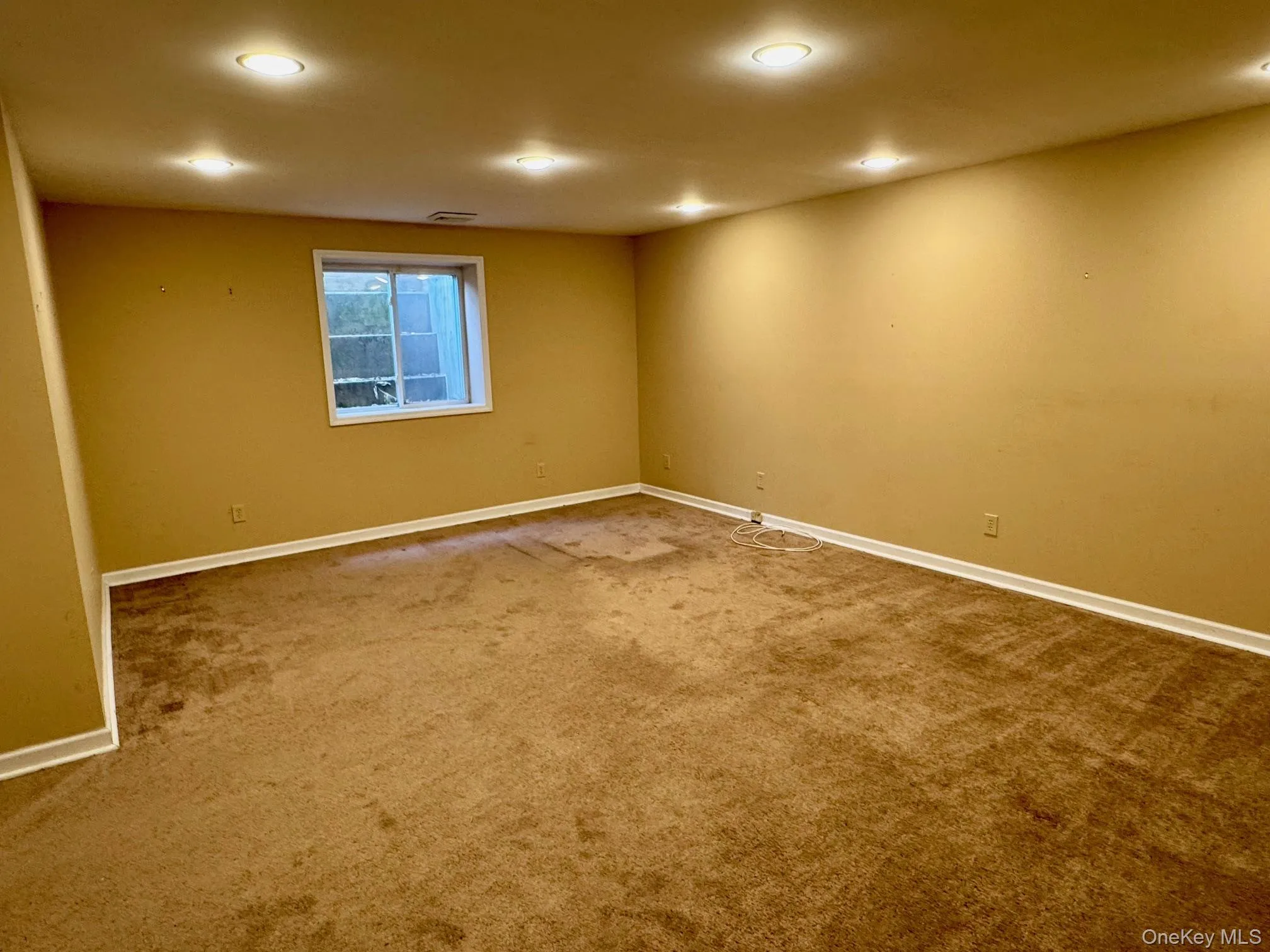 Spare room with dark colored carpet and recessed lighting Spare room with dark colored carpet and recessed lighting