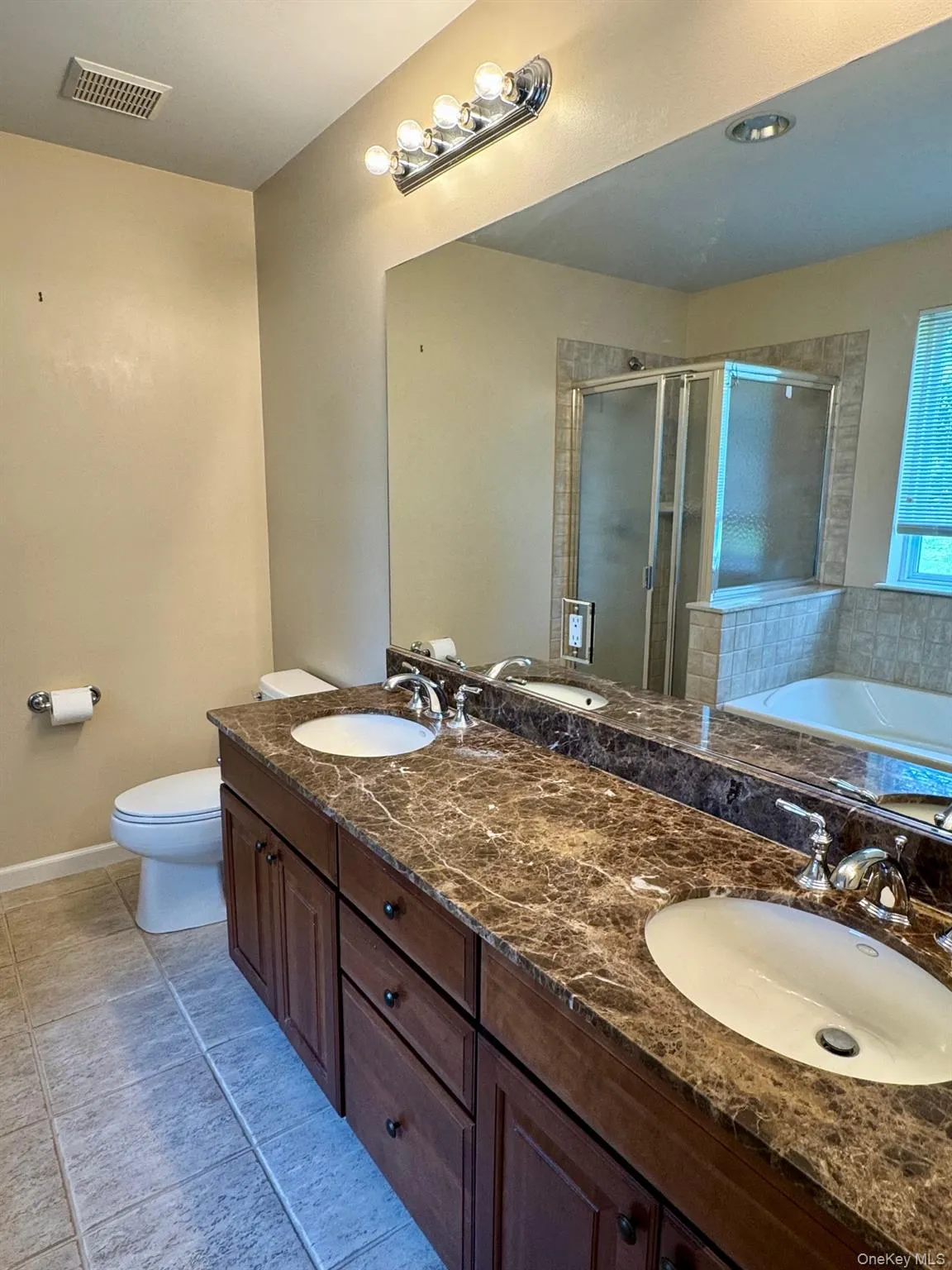 Bathroom featuring a stall shower, double vanity, a bath, and tile patterned flooring Bathroom featuring a stall shower, double vanity, a bath, and tile patterned flooring