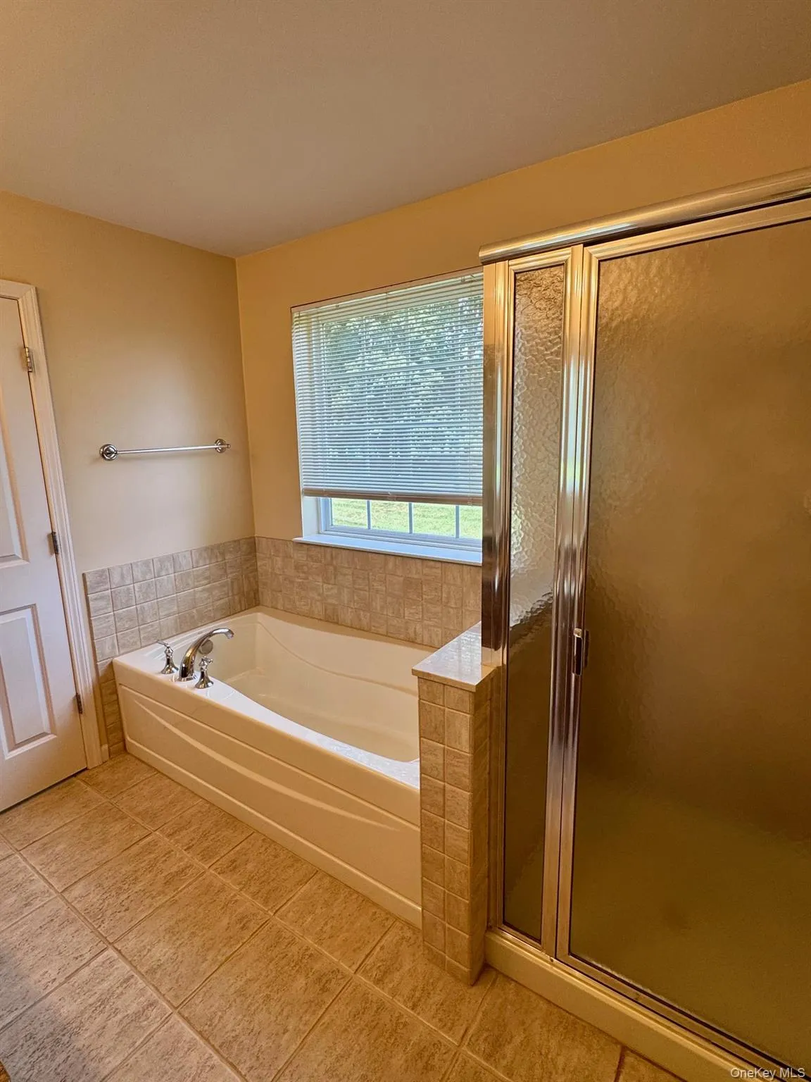 Bathroom featuring a garden tub, tile patterned floors, and a stall shower Bathroom featuring a garden tub, tile patterned floors, and a stall shower
