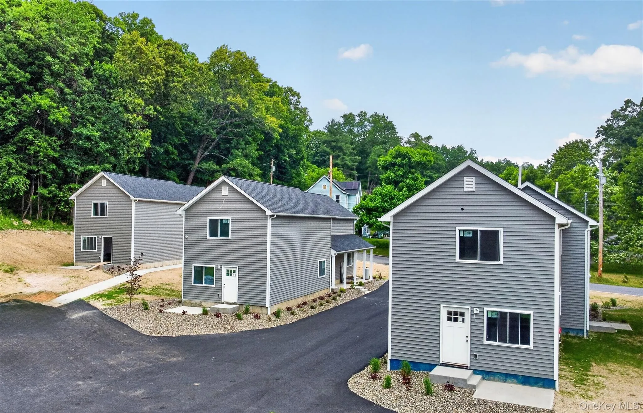 Newly constructed two-story residence featuring gray siding and white trim Newly constructed two-story residence featuring gray siding and white trim