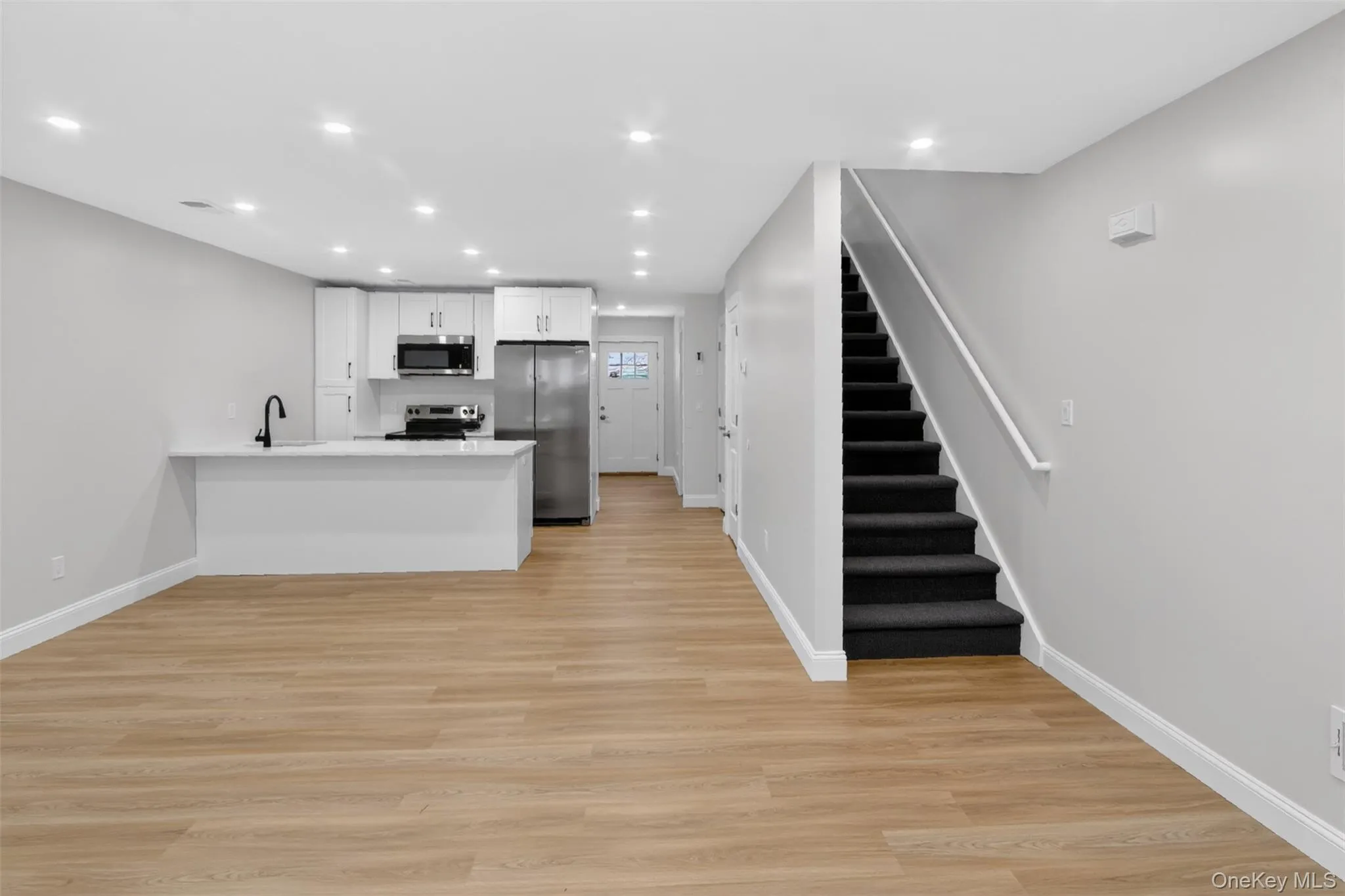 Open-concept living space with wood-finish flooring Open-concept living space with wood-finish flooring