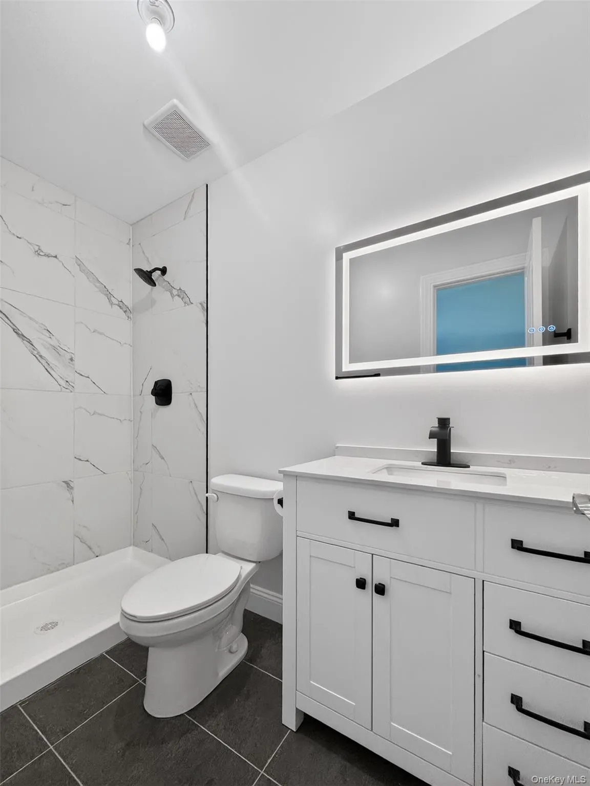 Bathroom featuring a white vanity with black hardware, a quartz countertop, and a rectangular undermount sink Bathroom featuring a white vanity with black hardware, a quartz countertop, and a rectangular undermount sink