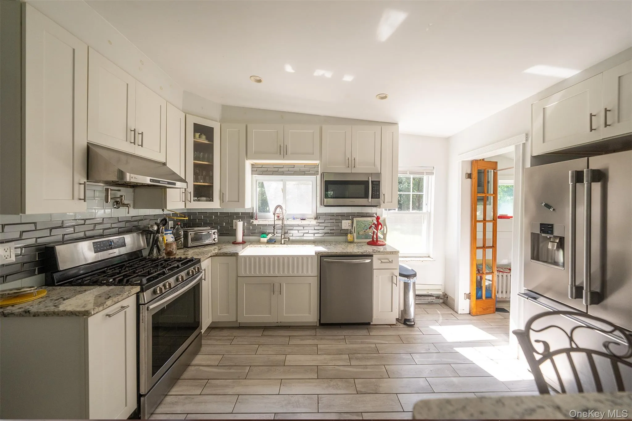 New kitchen layout with timeless finishes makes this a bright kitchen that catches the afternoon light over the kitchen sink. New kitchen layout with timeless finishes makes this a bright kitchen that catches the afternoon light over the kitchen sink.