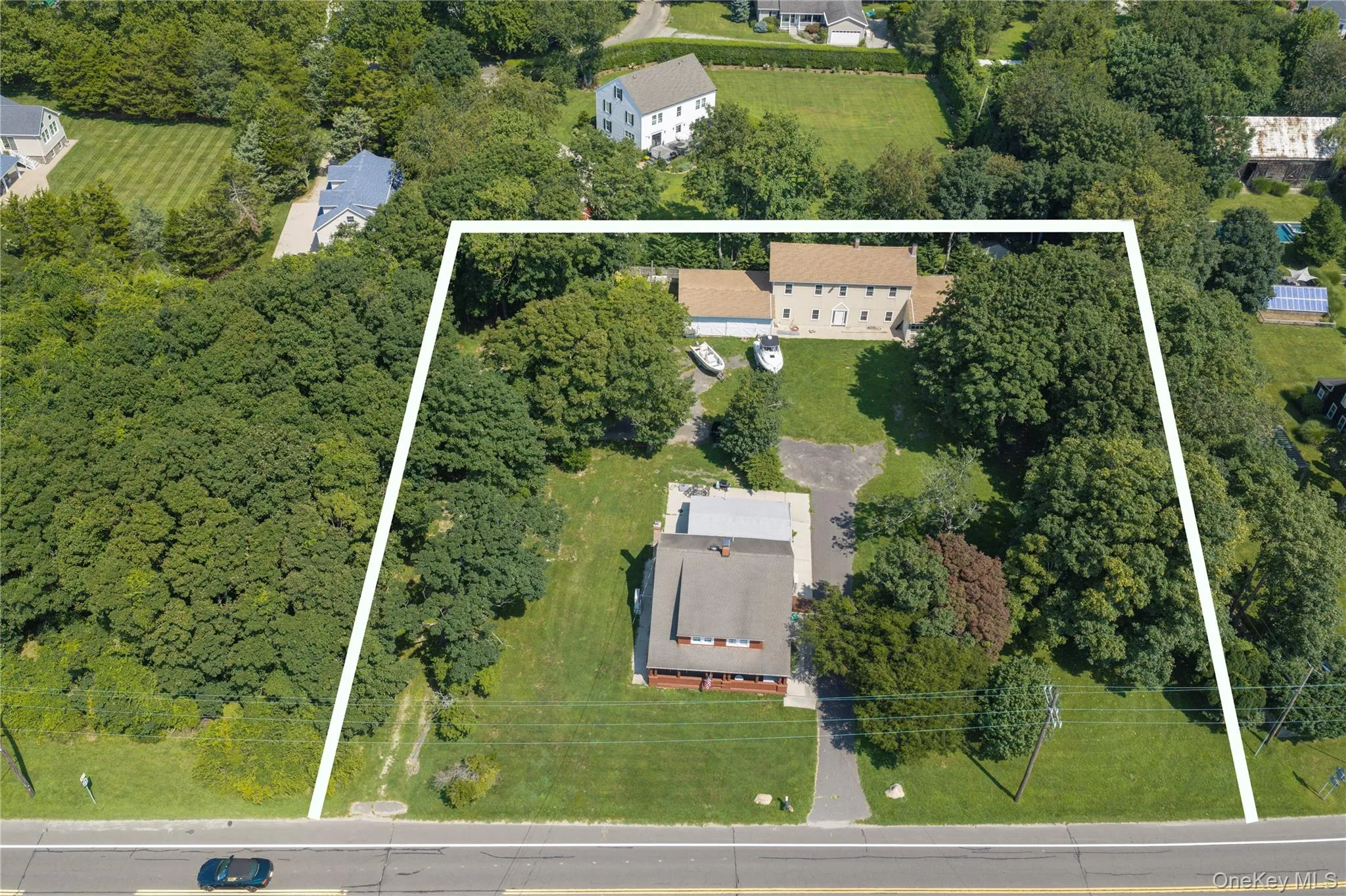 Front view of the Craftsman home renovation in 1920 with historic barn and garage in the backyard. The land to the left is preserved and will not be built upon and the house to the right has a pool and historic barn Front view of the Craftsman home renovation in 1920 with historic barn and garage in the backyard. The land to the left is preserved and will not be built upon and the house to the right has a pool and historic barn