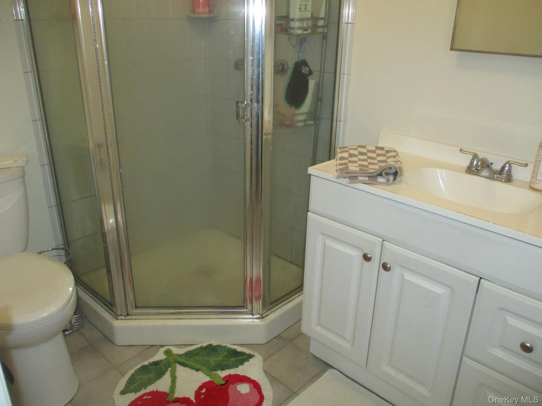 Full bathroom featuring toilet, vanity, a shower stall, and tile patterned flooring Full bathroom featuring toilet, vanity, a shower stall, and tile patterned flooring