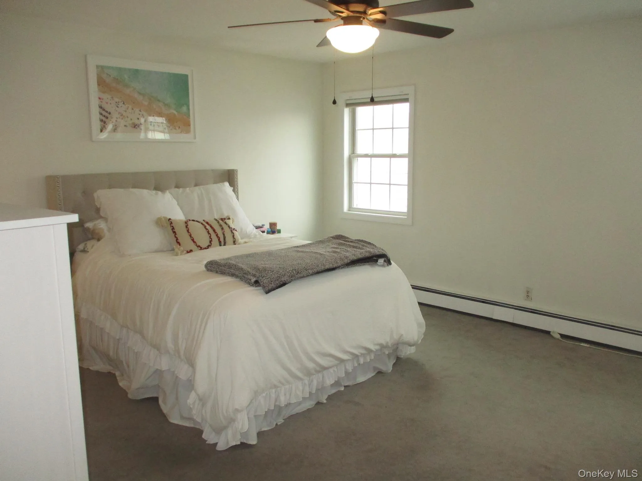 Bedroom with a baseboard heating unit, a ceiling fan, and carpet floors Bedroom with a baseboard heating unit, a ceiling fan, and carpet floors