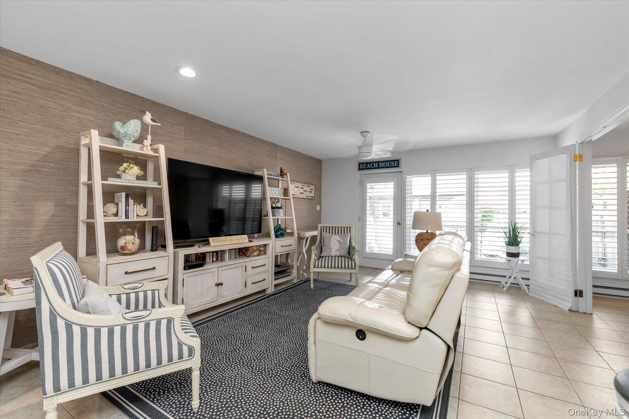 Living area featuring a textured accent wall, recessed lighting, and a ceiling fan Living area featuring a textured accent wall, recessed lighting, and a ceiling fan