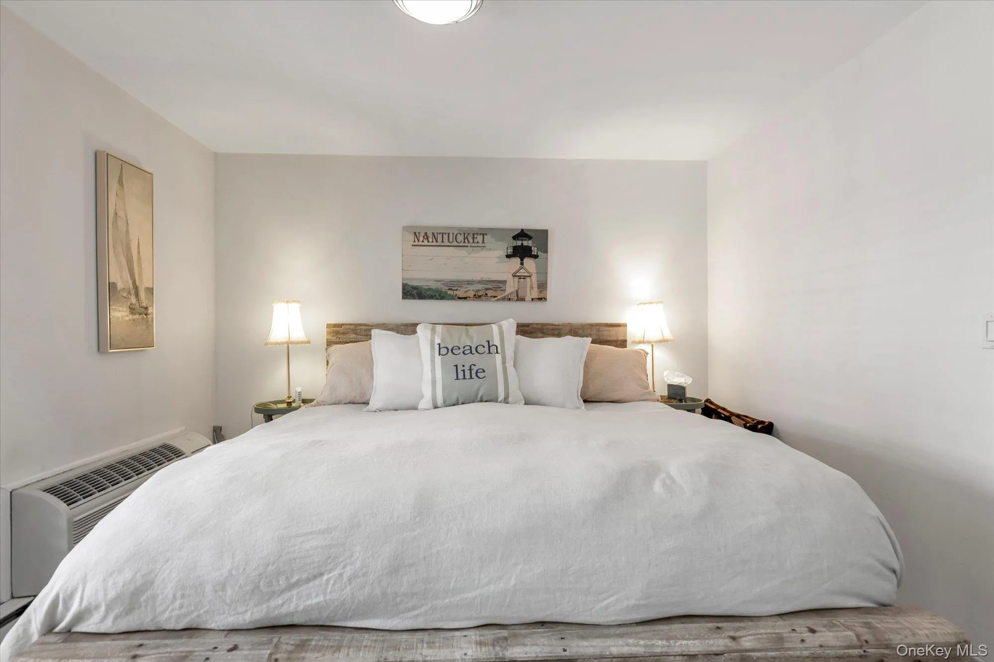 Bedroom featuring a wood-finish platform bed and a wall-mounted heating/cooling unit Bedroom featuring a wood-finish platform bed and a wall-mounted heating/cooling unit