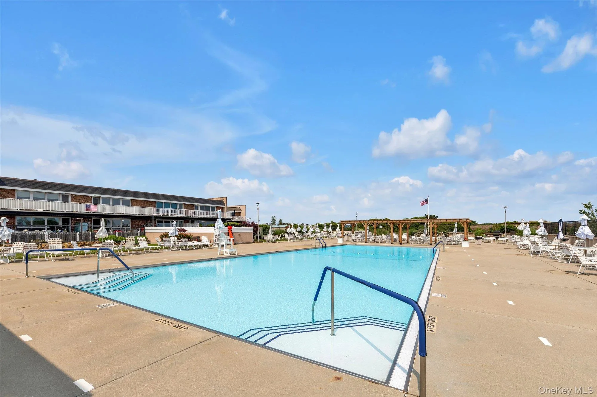 Expansive outdoor swimming pool with integrated steps and handrails Expansive outdoor swimming pool with integrated steps and handrails