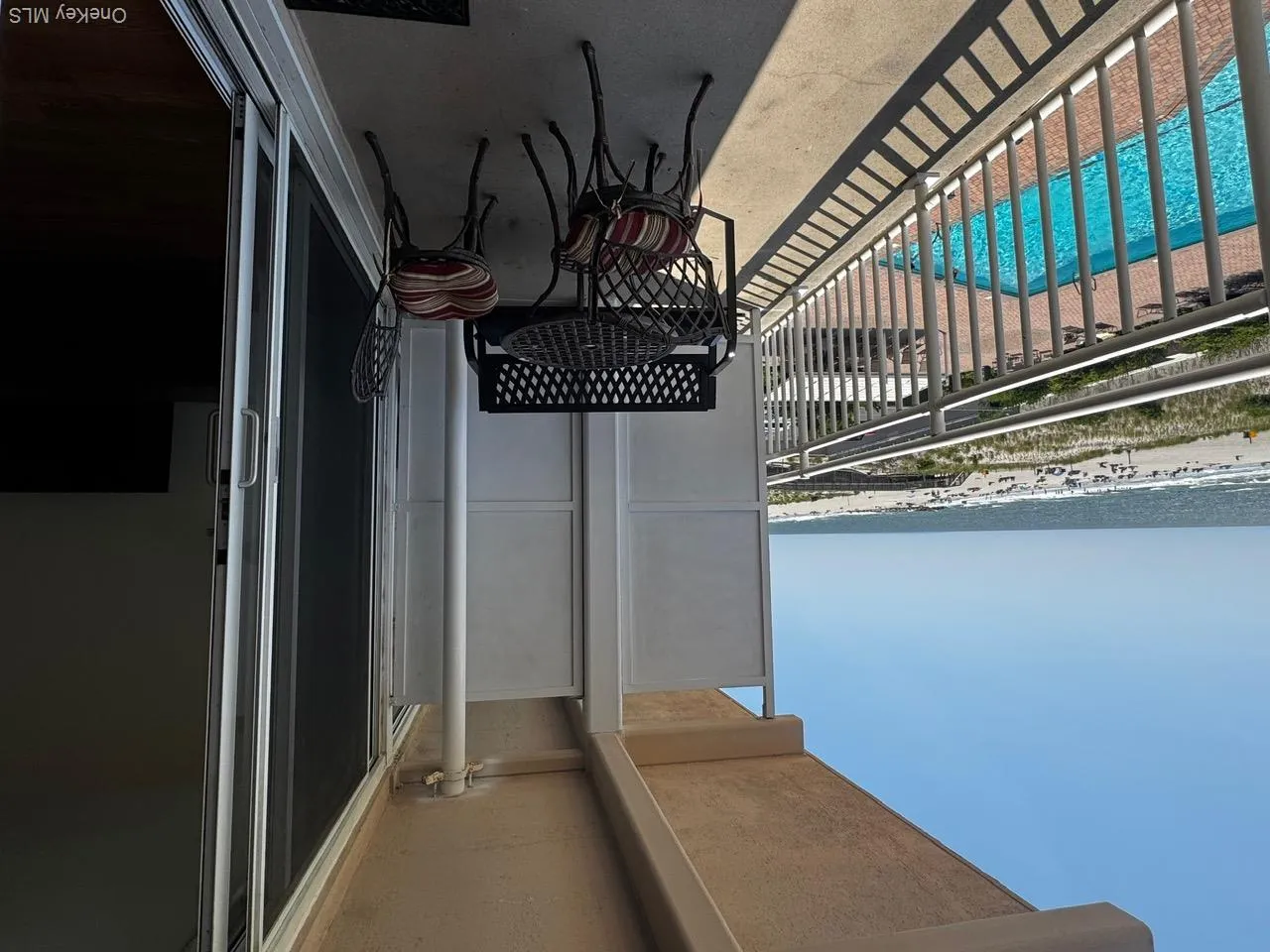 Balcony featuring view of pool and view of water and beach Balcony featuring view of pool and view of water and beach