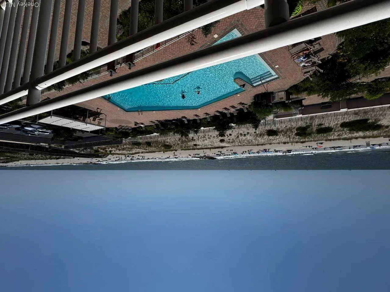 Community pool featuring view of water and beach Community pool featuring view of water and beach