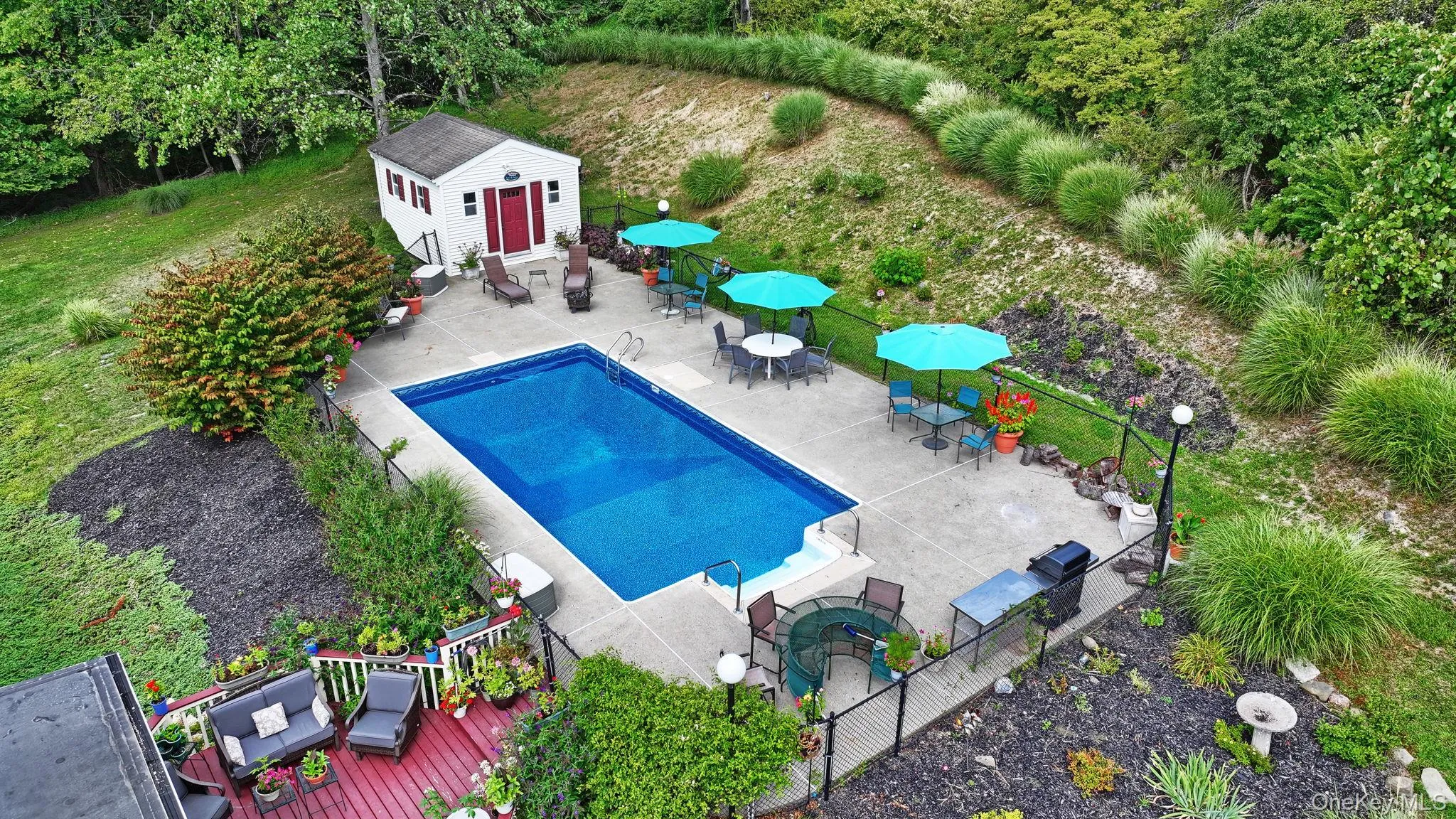 View of the pool area as well as some of the gardens and decking View of the pool area as well as some of the gardens and decking