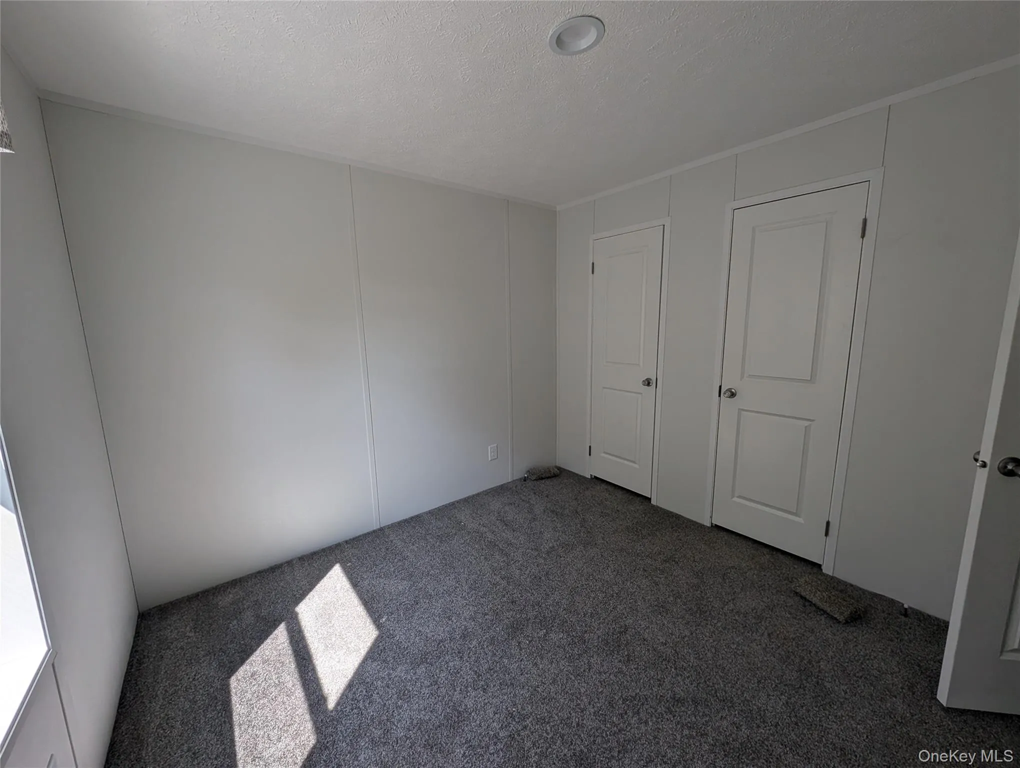 Unfurnished bedroom with carpet flooring Unfurnished bedroom with carpet flooring